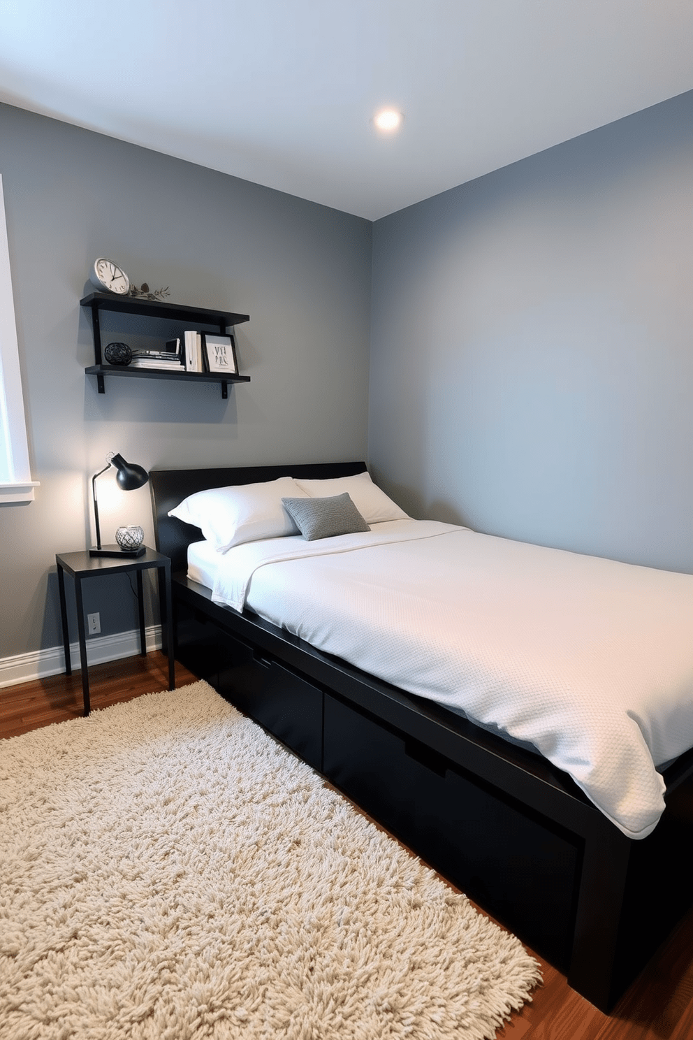 A cozy 10x10 bedroom featuring a platform bed with built-in under-bed storage drawers. The walls are painted in a soft gray hue, complemented by a plush area rug in a neutral tone. A small nightstand with a sleek lamp sits beside the bed, providing a warm glow. A wall-mounted shelf displays books and decorative items, enhancing the room's functionality and style.