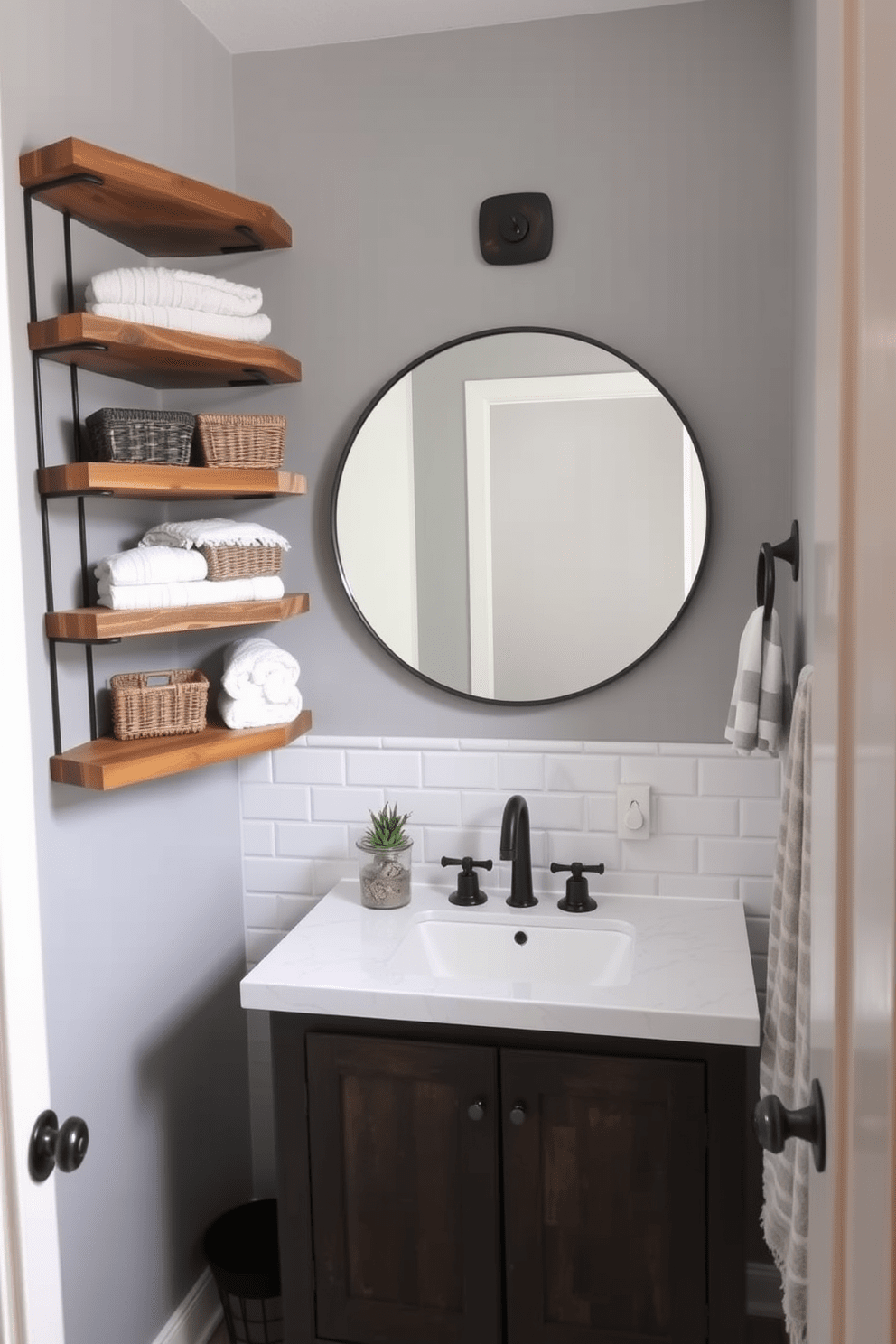 Open shelving creates a stylish storage solution in an 8x10 bathroom. The shelves are made of reclaimed wood, showcasing neatly arranged towels and decorative baskets, adding warmth and texture to the space. The walls are painted in a soft gray tone, complementing the white subway tile backsplash. A large round mirror above the sink reflects natural light, making the room feel more spacious and inviting.