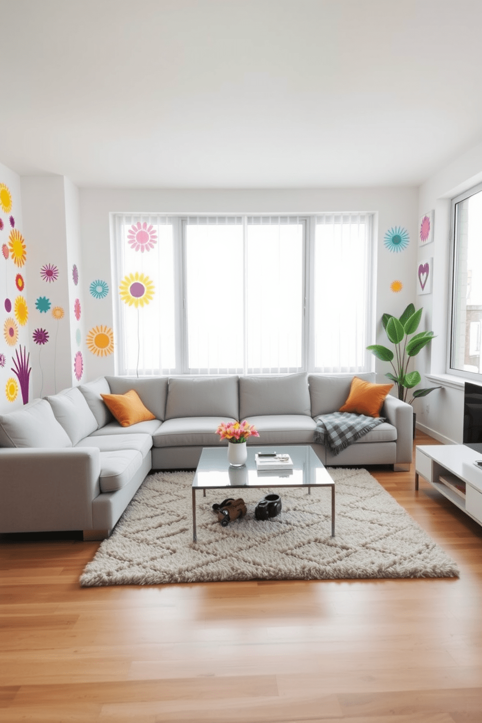 A modern apartment living room featuring a cozy sectional sofa in a light gray fabric. The walls are adorned with vibrant wall decals that can be easily changed to refresh the space. A sleek coffee table sits in front of the sofa, complemented by a plush area rug that adds warmth. Large windows allow natural light to flood the room, enhancing the cheerful atmosphere created by the colorful decals.