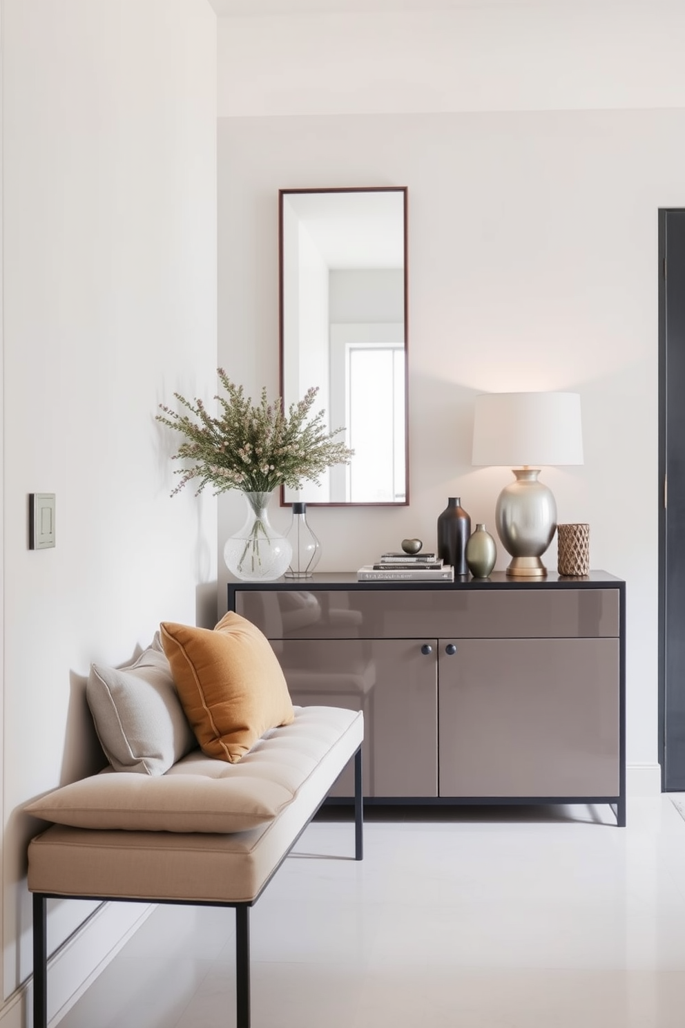 A stylish apartment entryway features a small bench with plush cushions positioned against the wall. The space is enhanced by a sleek console table adorned with decorative items and a large mirror above it, reflecting natural light.