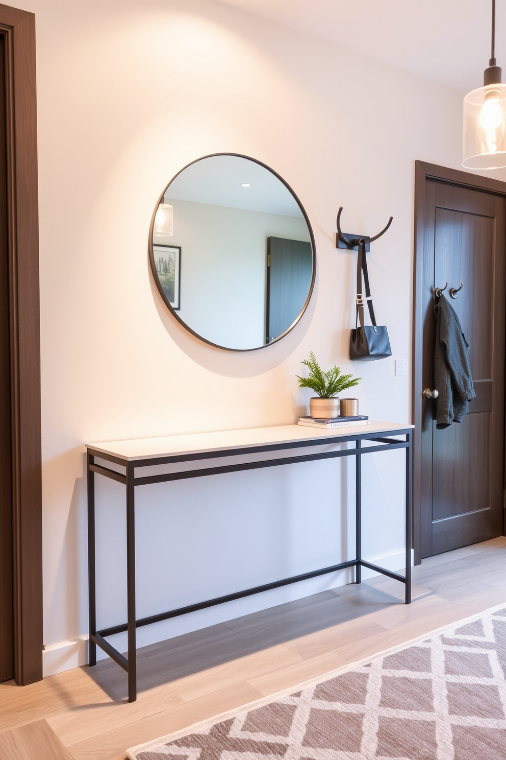 A stylish apartment entryway featuring a sleek console table against the wall. Above the table, a large round mirror reflects the space, while a set of modern hooks is installed for easy coat access. The floor is adorned with a geometric patterned rug that adds texture and warmth. Soft lighting from a pendant fixture illuminates the area, creating an inviting atmosphere.