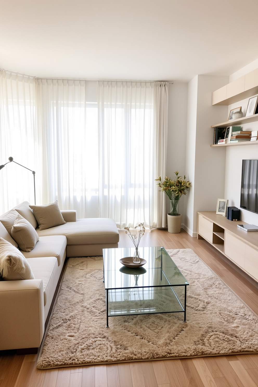 A serene apartment living room featuring a comfortable sectional sofa in soft beige fabric, accented by plush throw pillows in muted earth tones. A sleek glass coffee table sits in the center, surrounded by a cozy area rug that adds texture to the space. Large windows allow natural light to flood the room, showcasing sheer white curtains that gently diffuse the sunlight. On one wall, a minimalist entertainment unit holds a flat-screen TV, while decorative shelves display curated books and art pieces.