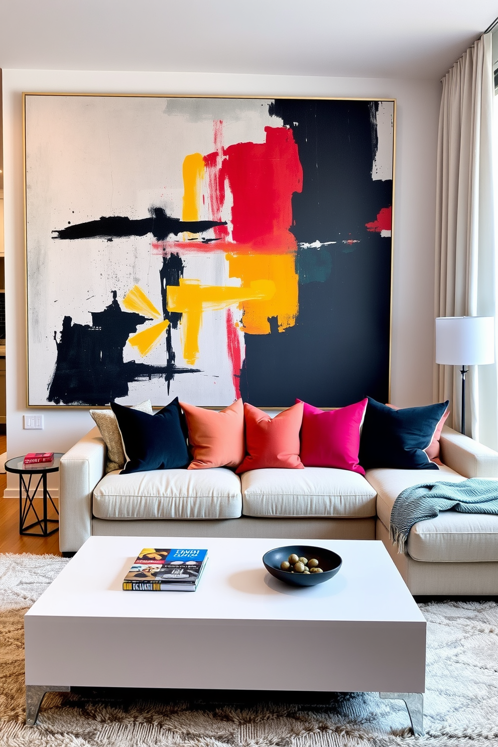 A stylish apartment living room featuring oversized artwork as a focal point. The walls are adorned with a large abstract painting that adds color and drama to the space. The room is furnished with a plush sectional sofa in a neutral tone, complemented by vibrant accent pillows. A sleek coffee table sits in front, surrounded by a cozy area rug that ties the design together.