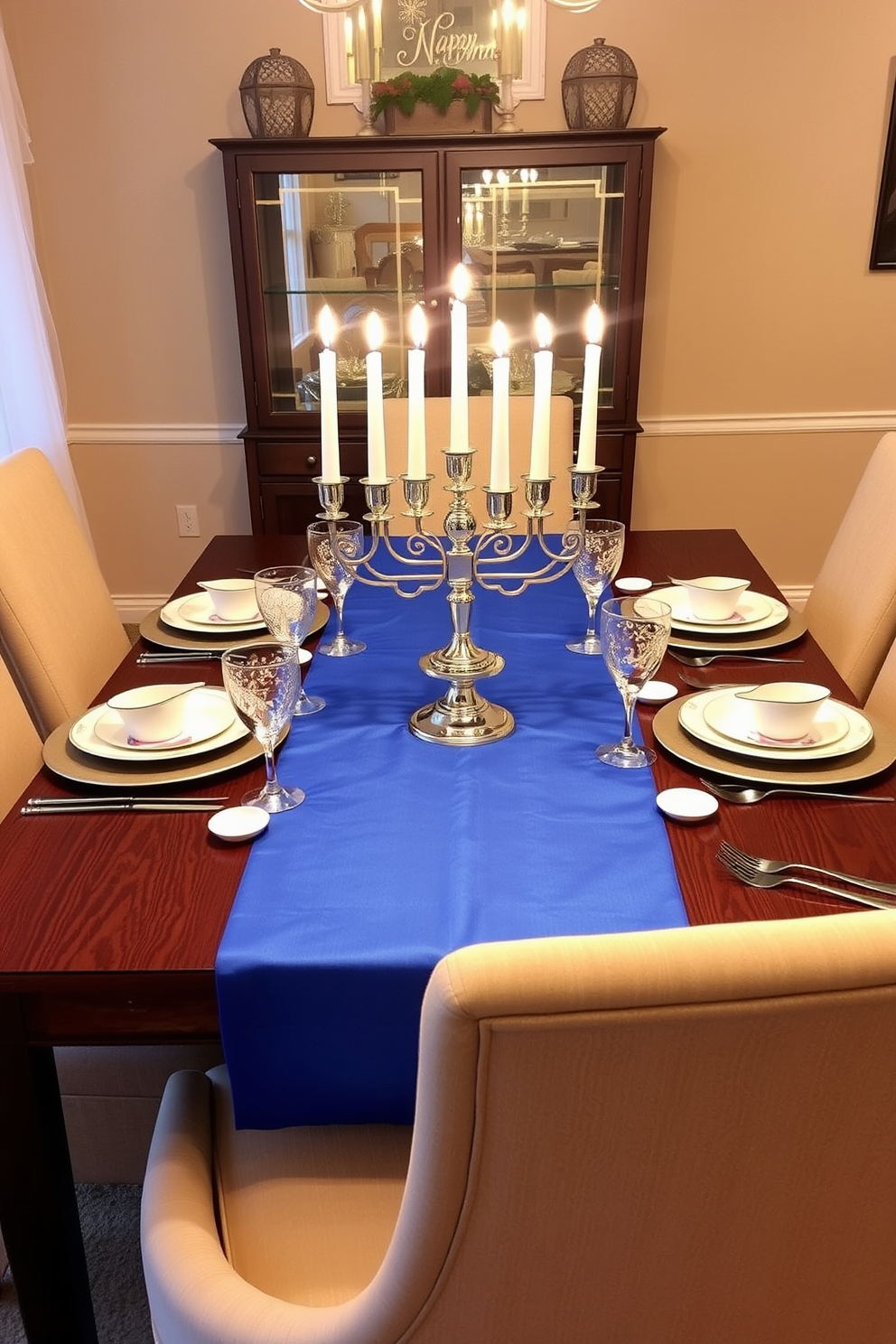 A festive dining table setting for Hanukkah. The table is adorned with a blue table runner that adds a pop of color, complemented by elegant white dinnerware and shimmering silver accents. Candles are arranged in a beautiful menorah at the center, casting a warm glow. Surrounding the table are plush chairs upholstered in a soft fabric, creating an inviting atmosphere for family gatherings.