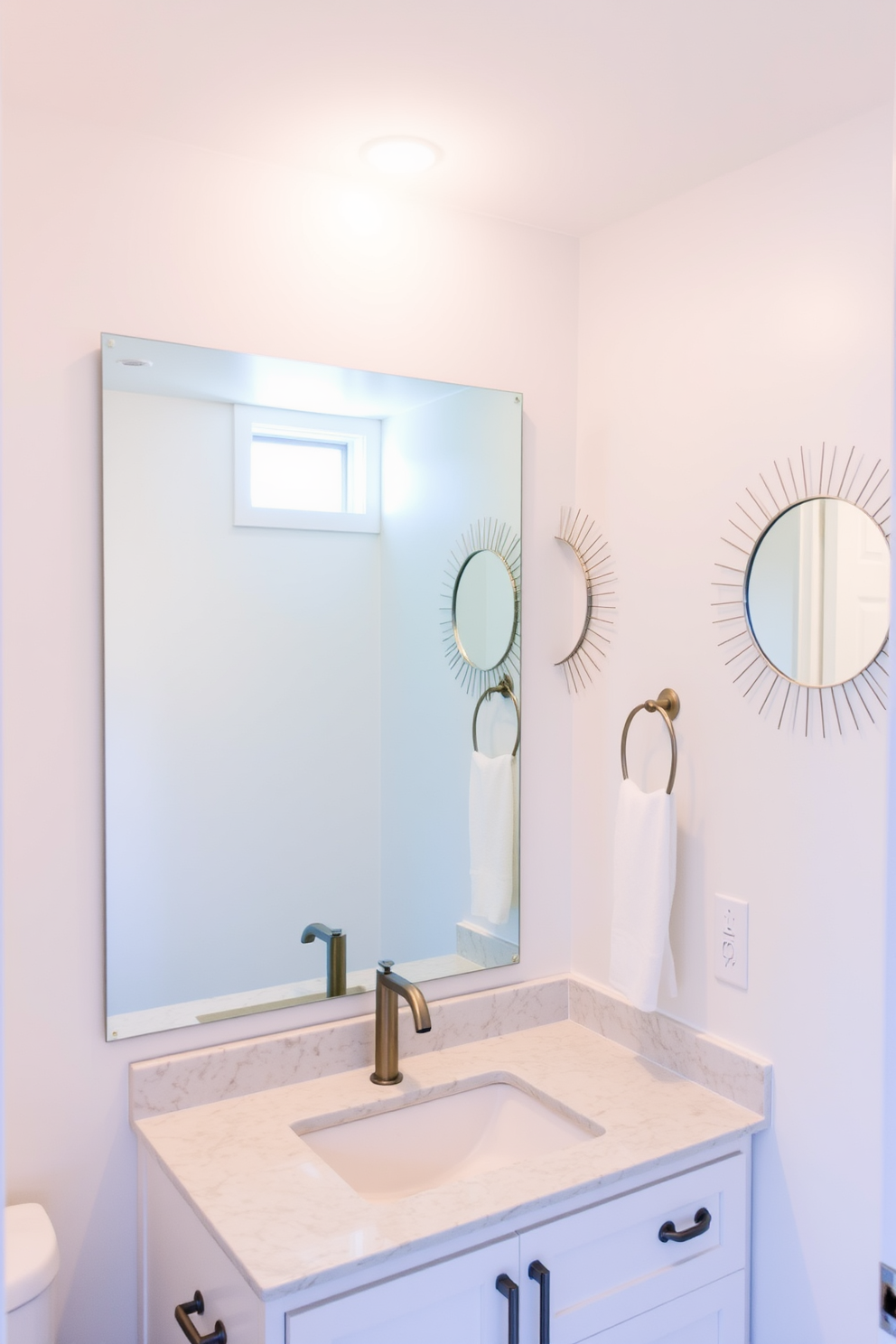 A basement bathroom featuring creative mirror placements that maximize light reflection. The design includes a large frameless mirror above the sink and smaller decorative mirrors on the walls to enhance brightness. The walls are painted in a light, airy color to complement the natural light from a small window. Sleek fixtures and a modern vanity with a quartz countertop complete the sophisticated look.