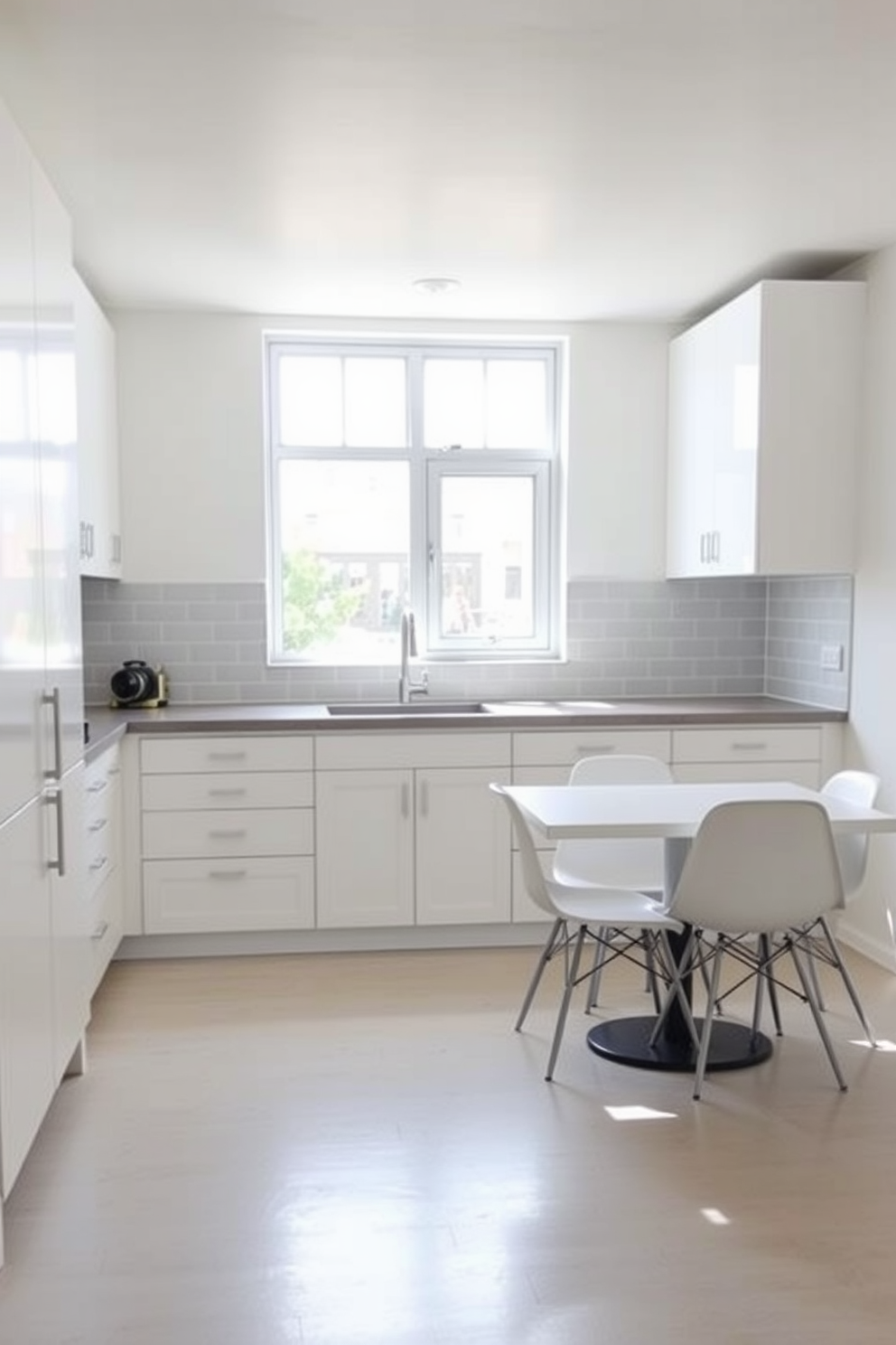 A minimalist basement kitchen featuring sleek cabinetry in a soft white finish. The countertop is a polished concrete surface, and the backsplash consists of simple subway tiles in a light gray hue. Natural light floods the space through a large window, illuminating the open layout. A small dining table with minimalist chairs sits adjacent to the kitchen area, creating a functional yet stylish environment.