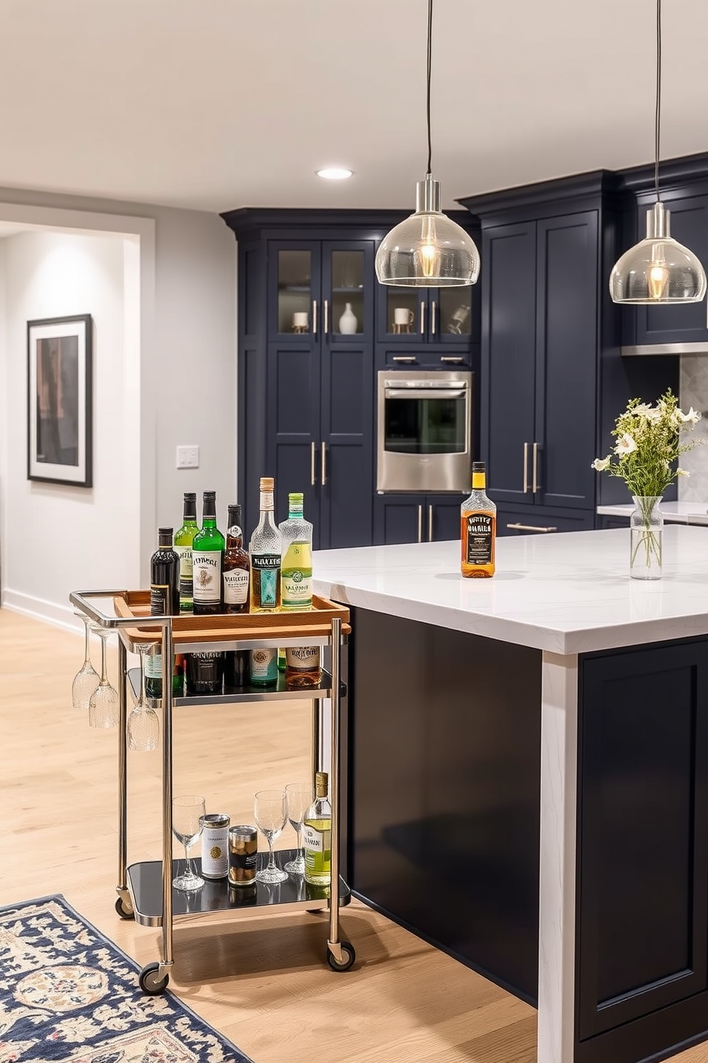 A stylish bar cart with a sleek metal frame and a wooden top showcases an array of premium spirits and glassware. The cart features two shelves, one for bottles and another for mixers, complemented by elegant stemware hanging from the side. In a modern basement kitchen, the design incorporates a spacious island with a waterfall countertop made of quartz. The cabinetry is a deep navy blue, providing a striking contrast to the light-colored walls and flooring, while pendant lights add warmth and style above the island.