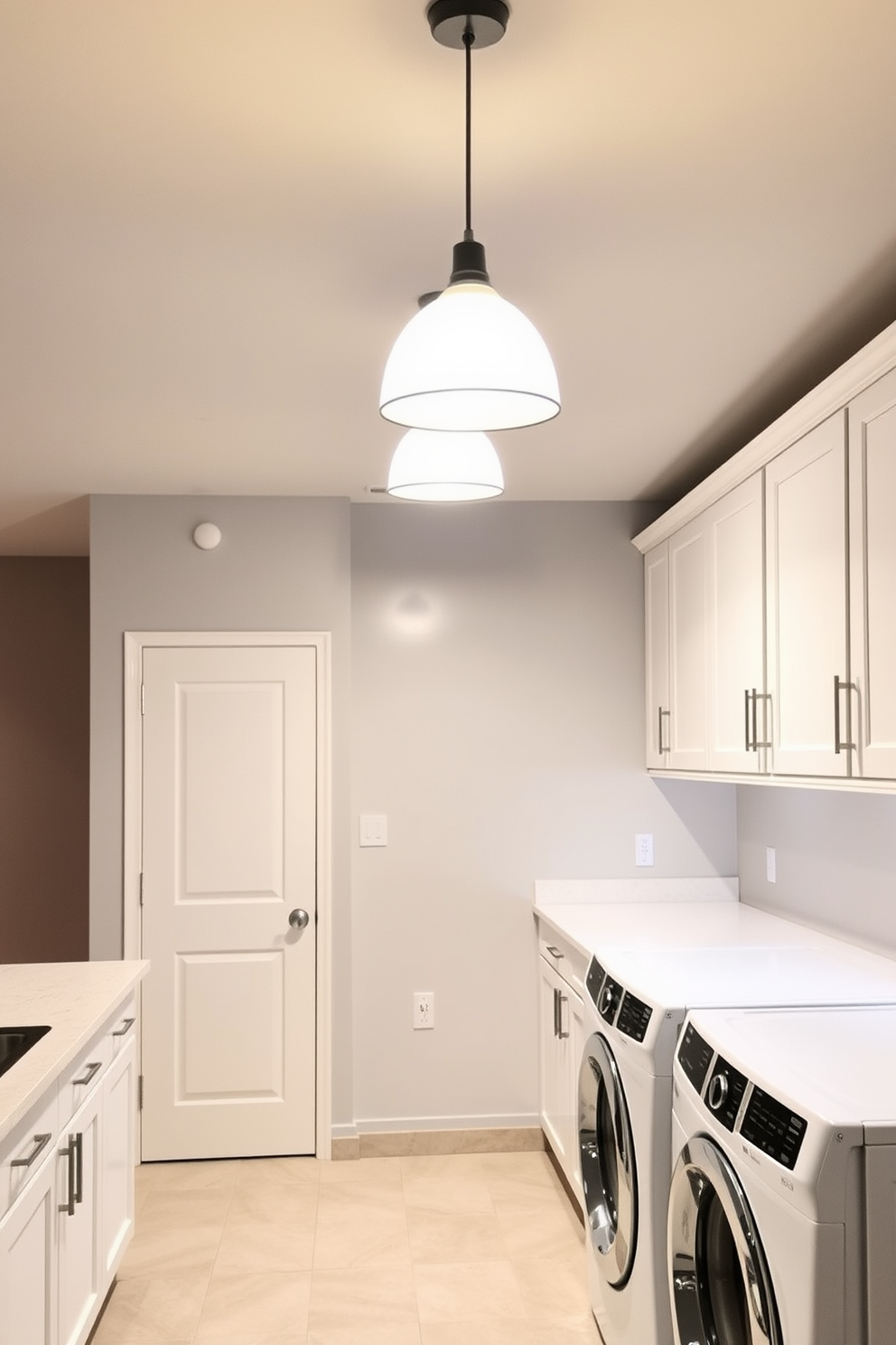 Bright pendant lighting hangs gracefully from the ceiling, casting a warm glow over the spacious basement laundry room. The walls are painted in a soft gray, complementing the sleek white cabinetry and modern appliances that enhance the overall functionality of the space.