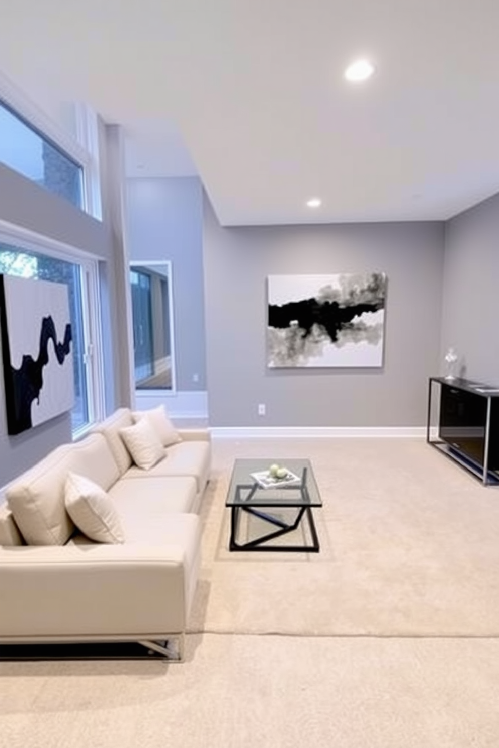 A sleek basement living room features a low-profile sectional sofa in a neutral color, paired with a glass coffee table that complements the space. The walls are painted in a soft gray, creating a calm atmosphere, while a large abstract painting adds a touch of modern art. Minimalistic furniture pieces include a slim console table against one wall, adorned with a few carefully chosen decorative items. Large windows allow natural light to flood the room, enhancing the open feel and showcasing a simple area rug that ties the space together.