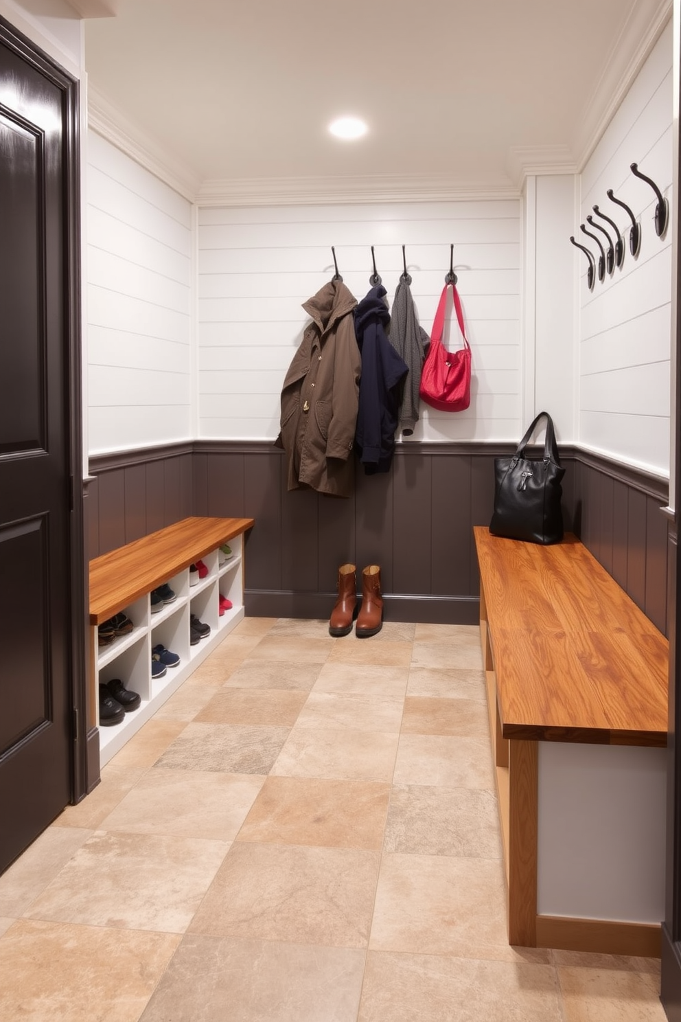 A functional basement mudroom features easy-to-clean surfaces that enhance durability and practicality. The walls are lined with waterproof paneling, while the floor is covered in large, textured ceramic tiles that resist stains and moisture. Incorporated into the design are built-in benches with storage underneath for shoes and outdoor gear. Hooks are mounted on the wall for coats and bags, creating an organized and welcoming space.