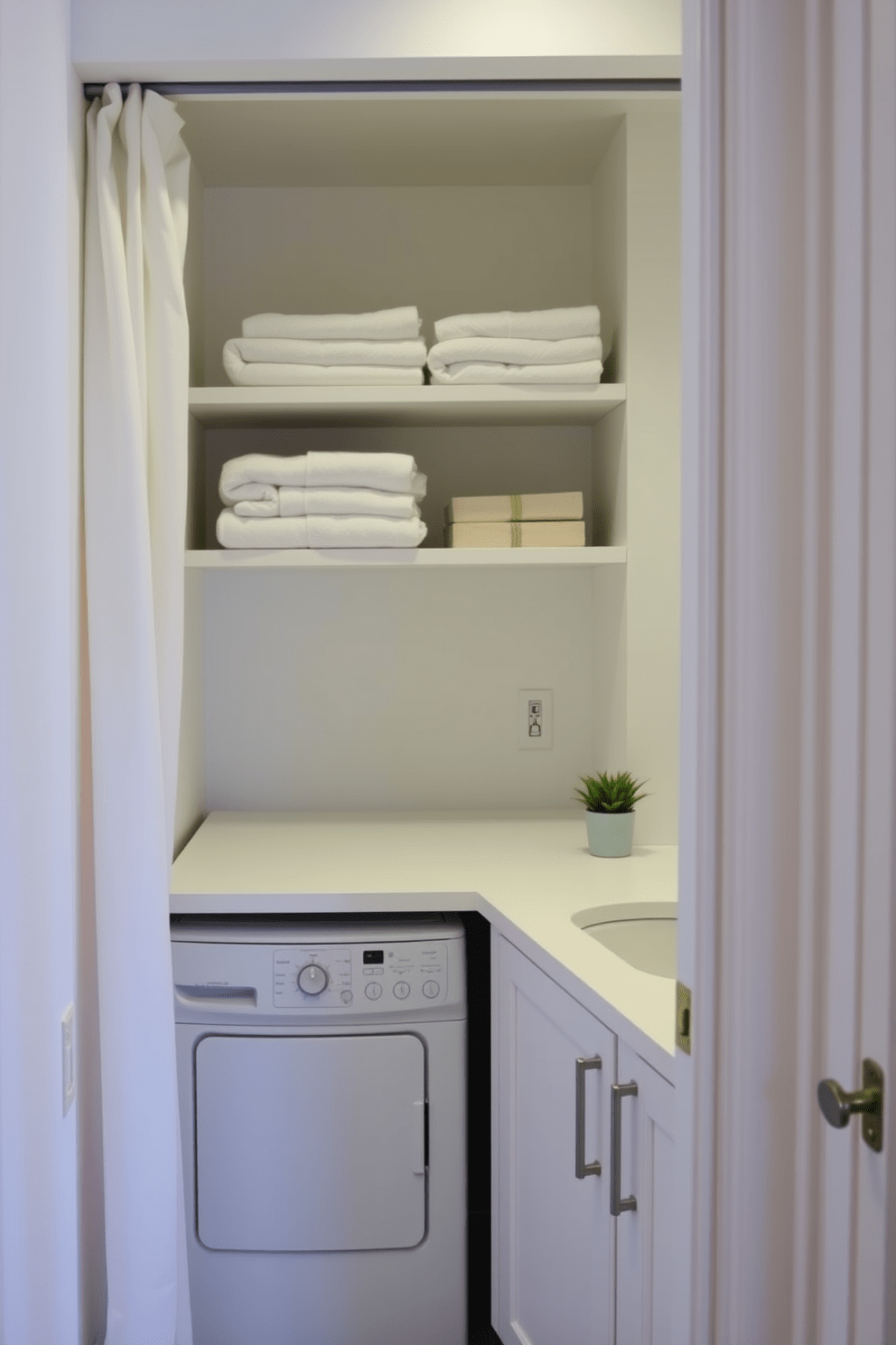 A cozy laundry nook with a soft curtain separation from the bathroom. The space features a compact washer and dryer stacked next to a sleek countertop for folding clothes. Above the countertop, open shelving displays neatly folded towels and laundry supplies. The walls are painted in a light, airy color, while a small potted plant adds a touch of greenery to the corner.