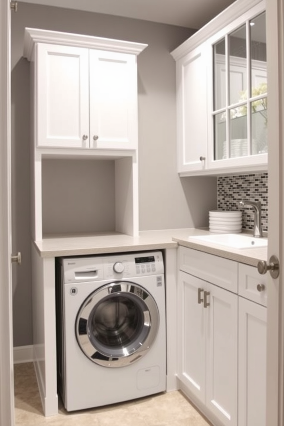 A functional laundry area seamlessly integrated into the bathroom space. The design features a stacked washer and dryer tucked into a built-in cabinet with a countertop for folding clothes. Bright white cabinets provide ample storage for laundry supplies, while a small sink is included for hand-washing delicate items. The walls are painted in a soft gray hue, complemented by a stylish backsplash made of mosaic tiles.