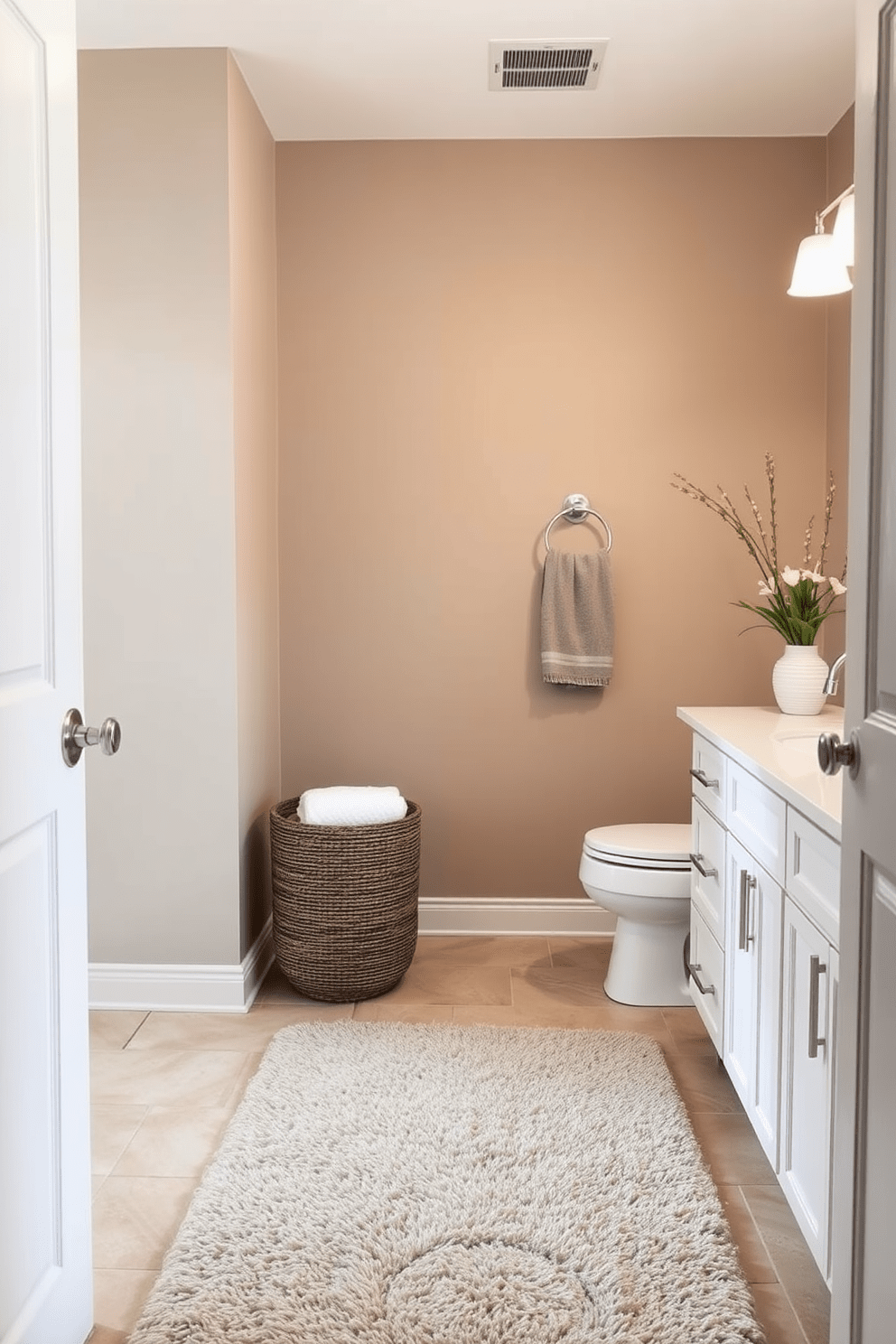 A serene bathroom setting featuring neutral greige walls that create a calming atmosphere. The space is accented with white cabinetry and brushed nickel fixtures for a modern touch. Soft lighting illuminates the room, enhancing the warm tones of the greige paint. A plush area rug in a complementary shade adds comfort and style underfoot.