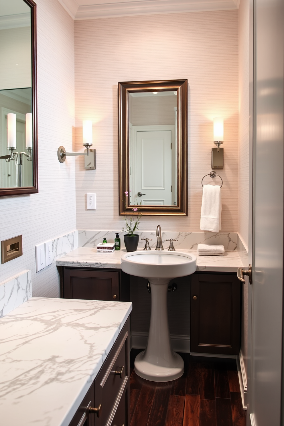 Luxury marble countertops for elegance. The powder room features a chic design with soft lighting and elegant fixtures. A sleek pedestal sink complements the marble surfaces. The walls are adorned with a subtle textured wallpaper in a light hue. A large framed mirror reflects the sophisticated ambiance. Decorative accents include a small potted plant and plush hand towels. Elegant sconces provide warm lighting on either side of the mirror. The flooring is a rich dark wood that enhances the overall luxury feel.