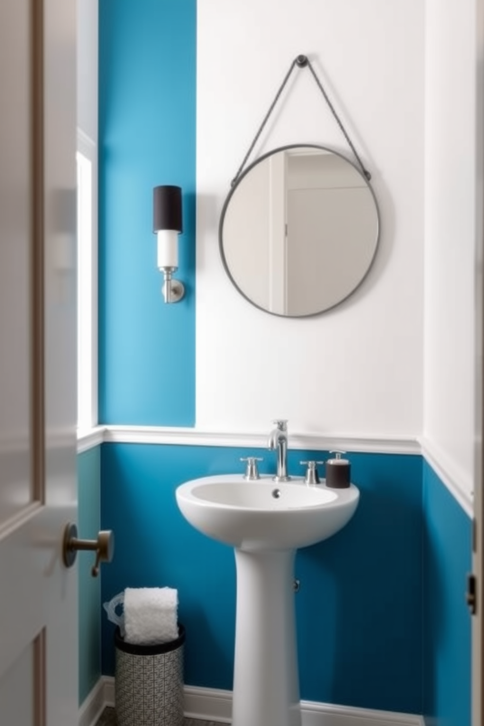 Accent wall with bold paint color. The wall features a striking deep blue hue that contrasts beautifully with the light neutral tones of the surrounding walls. The powder room includes a sleek pedestal sink with a modern faucet. A round mirror with a thin black frame hangs above the sink, enhancing the room's contemporary feel.