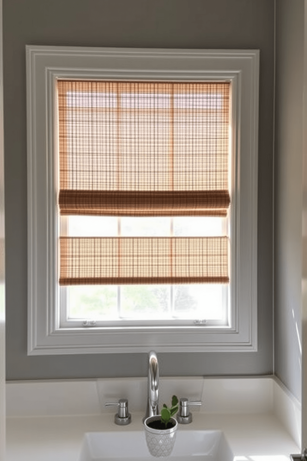 A serene bathroom window adorned with bamboo shades allows soft, diffused light to filter in, creating a warm and inviting atmosphere. The shades add a natural texture that complements the minimalist decor, enhancing the overall aesthetic of the space. The window frame is painted in a crisp white, contrasting beautifully with the earthy tones of the bamboo. Below the window, a sleek countertop with a small potted plant adds a touch of greenery, harmonizing with the organic elements in the room.