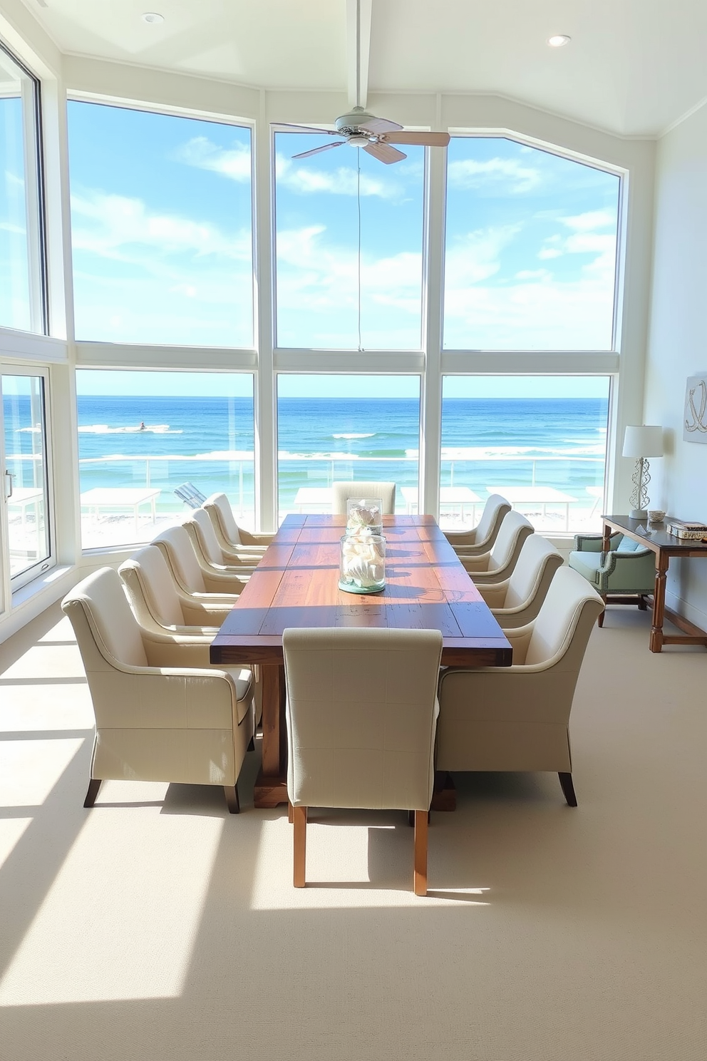 A beach dining room with large windows that frame stunning ocean views. The space features a long wooden table surrounded by comfortable, upholstered chairs in light colors. Natural light floods the room, highlighting the soft blue and sandy beige color palette. Decorative elements include seashell centerpieces and nautical-themed wall art to enhance the coastal atmosphere.