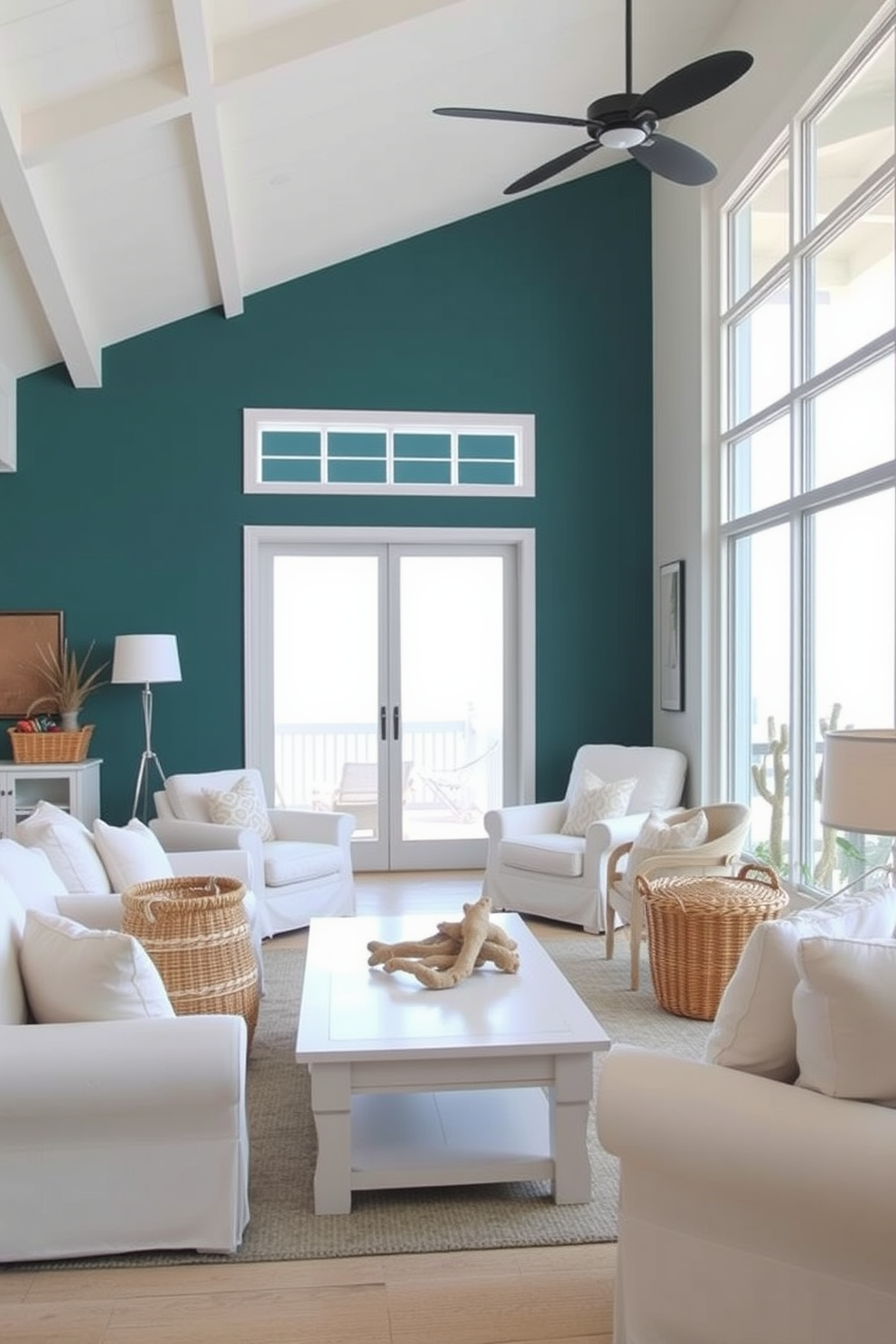 A beach living room featuring an accent wall painted in deep teal. The room is filled with natural light, showcasing white furniture and soft beige accents. Coastal decor elements include woven baskets and driftwood accents. Large windows offer a view of the ocean, enhancing the serene atmosphere.