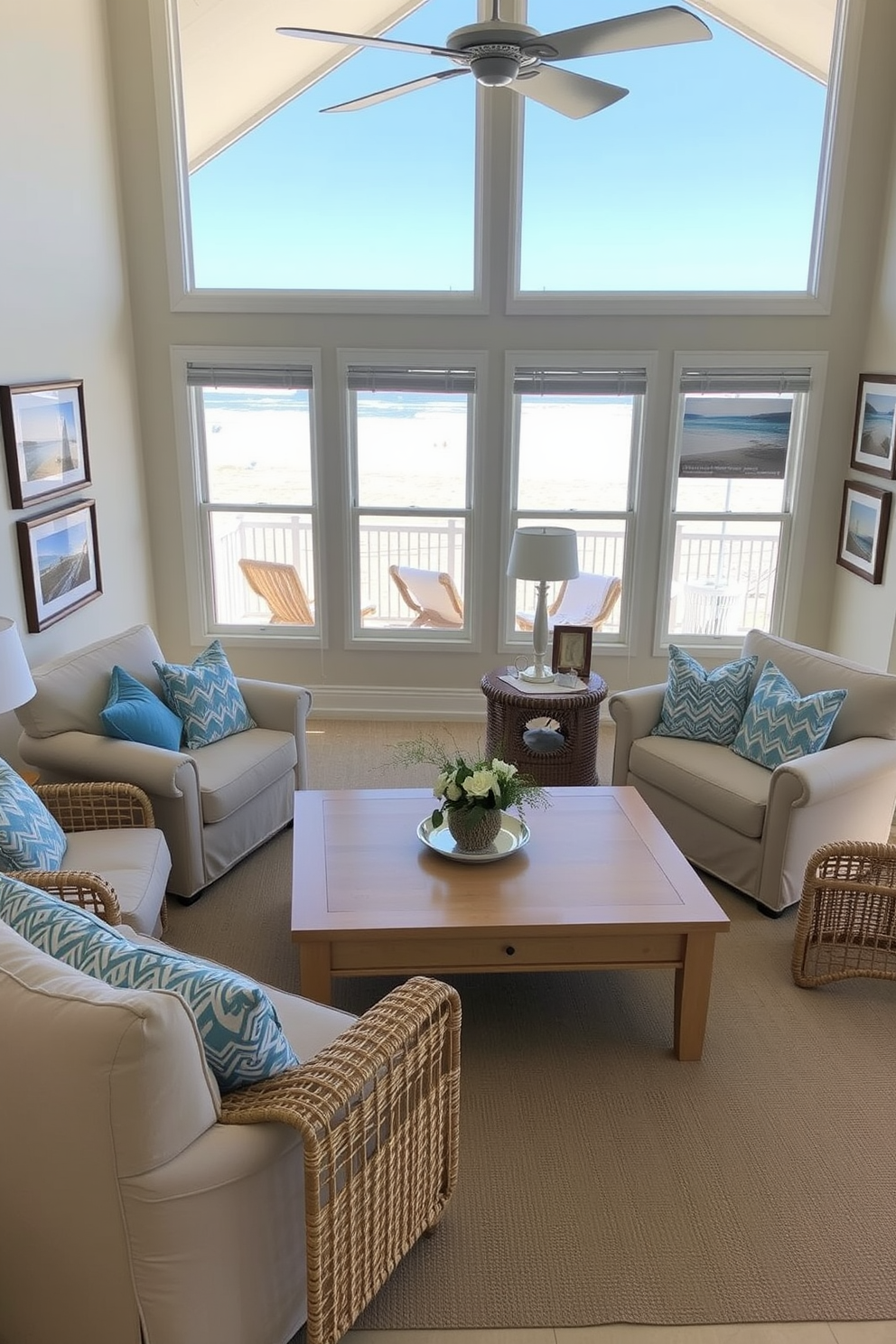 Framed beach photographs adorn the walls, adding a personal touch to the space. The living room features a soft beige sofa paired with ocean-inspired blue and white accent pillows. A light wood coffee table sits in the center, surrounded by woven rattan chairs. Large windows allow natural light to flood the room, showcasing views of the beach outside.