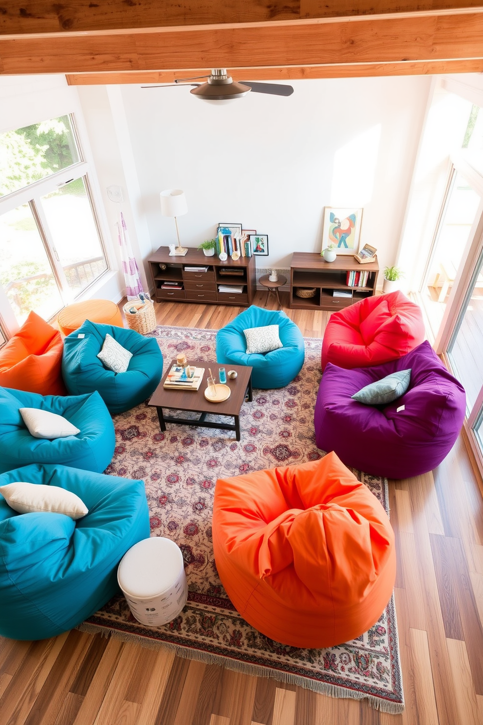 A cozy living room filled with colorful bean bags arranged for flexible seating. The space features a mix of bright and neutral tones, with a large area rug anchoring the seating area. In one corner, a cluster of oversized bean bags invites relaxation, while a low coffee table offers a casual spot for drinks and snacks. Natural light streams in through large windows, enhancing the inviting atmosphere of the room.