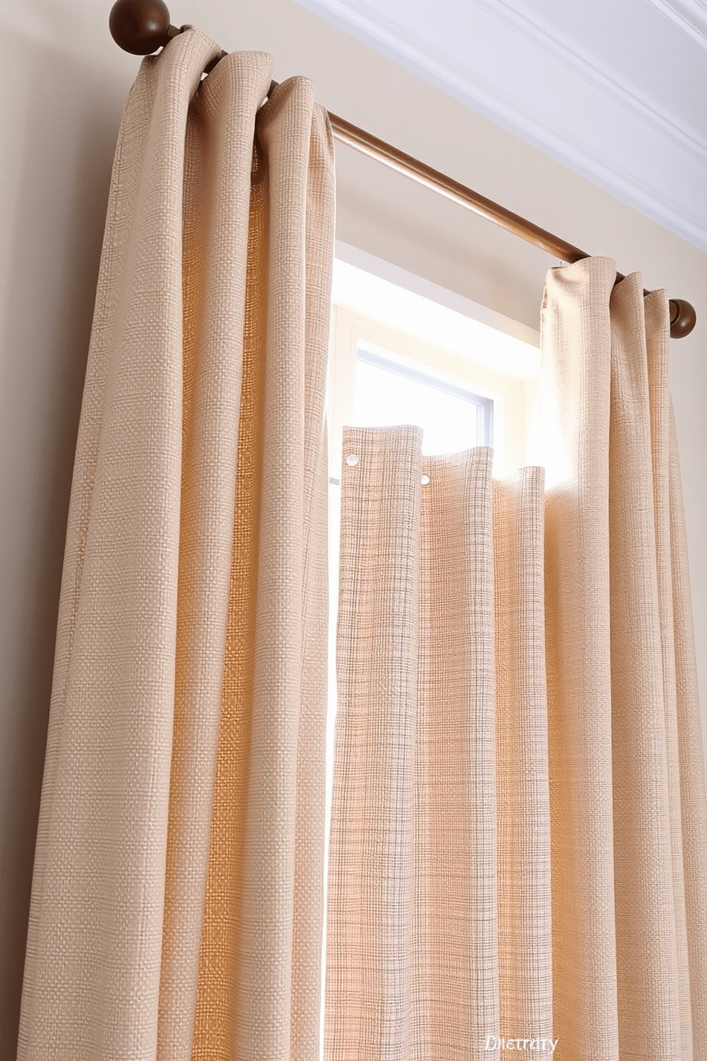 Textured fabric curtains drape elegantly from a polished wooden rod, adding a touch of luxury to the bedroom. The soft, muted colors of the curtains complement the room's decor, creating a cozy and inviting atmosphere. The fabric features a subtle pattern that enhances the visual interest without overwhelming the space. These curtains gently filter the natural light, casting a warm glow across the room while providing privacy.