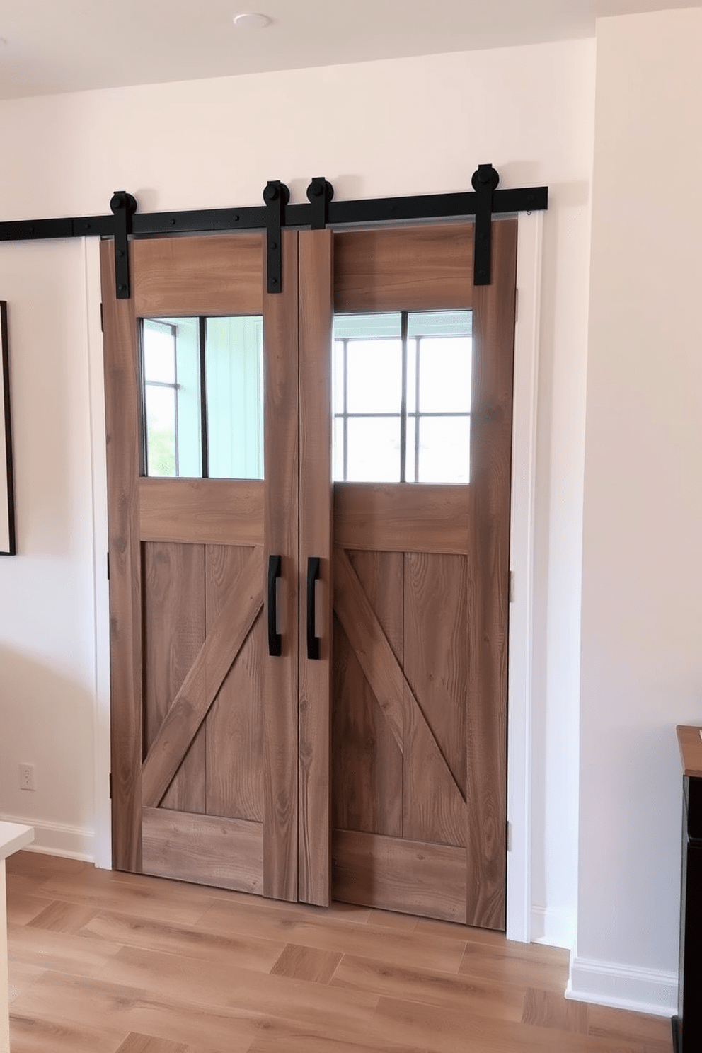 A modern barn door with rustic charm features a sliding mechanism that showcases a weathered wood finish. The door is adorned with black metal hardware, seamlessly blending contemporary design with traditional farmhouse aesthetics. Incorporate large glass panels within the door to allow natural light to flow between spaces. The surrounding wall is painted in a soft white, enhancing the door's warm tones and creating a cozy atmosphere.