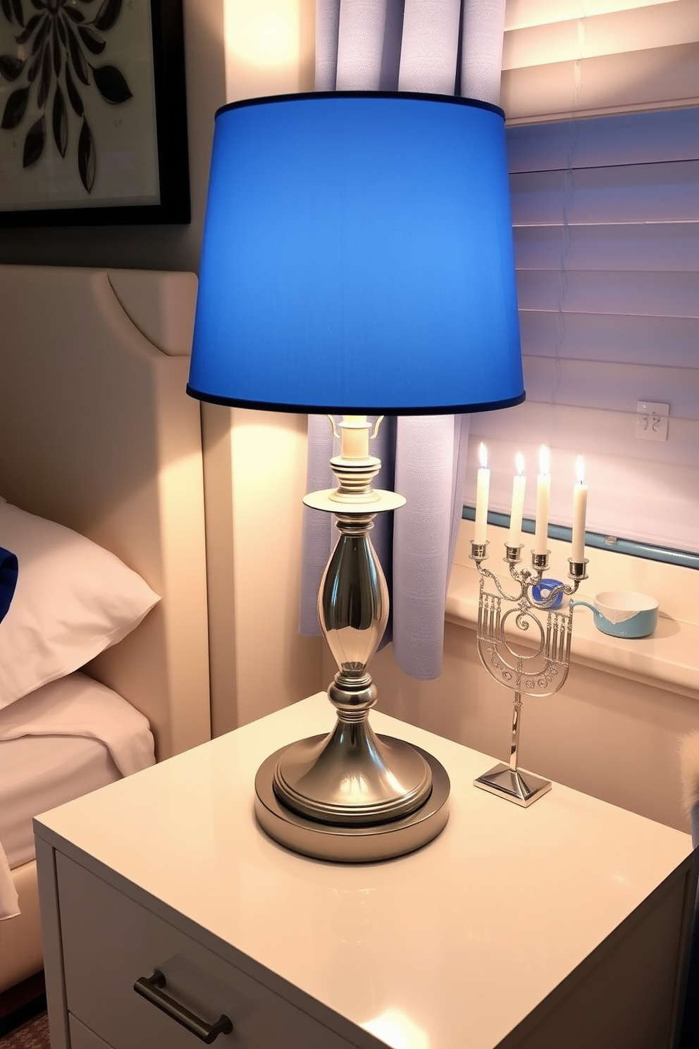 An elegant table lamp with a blue shade sits atop a sleek nightstand in a cozy bedroom. The soft glow of the lamp illuminates the room, creating a warm and inviting atmosphere perfect for relaxation. For Hanukkah decorating ideas, the bedroom features a tasteful arrangement of blue and silver decorations. Delicate menorah candles are placed on the windowsill, enhancing the festive spirit while complementing the overall color scheme.