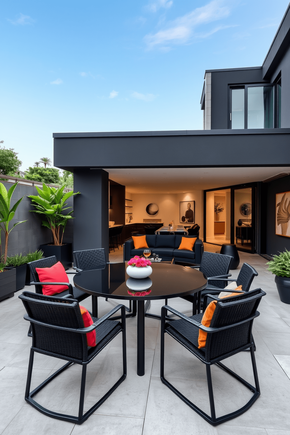 A stylish patio setting featuring sleek black outdoor furniture. The arrangement includes a modern dining table surrounded by comfortable black chairs, accented by vibrant cushions. A contemporary black apartment design showcasing open spaces and minimalist decor. The living room features a plush black sofa paired with a glass coffee table and elegant art pieces on the walls.