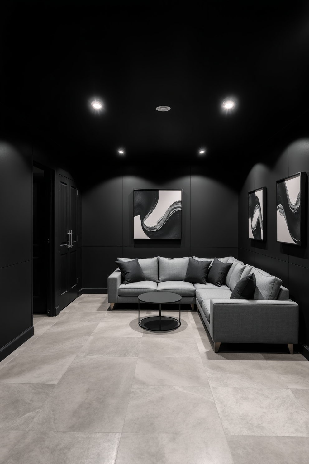 A sleek black basement design featuring a monochrome color scheme with shades of black and gray. The walls are adorned with textured black panels, and the flooring consists of polished gray concrete, creating a modern and sophisticated atmosphere. In one corner, a plush gray sectional sofa is complemented by black accent pillows and a minimalist coffee table. Ambient lighting is provided by recessed fixtures in the ceiling, casting a warm glow over the space while highlighting the contemporary artwork on the walls.