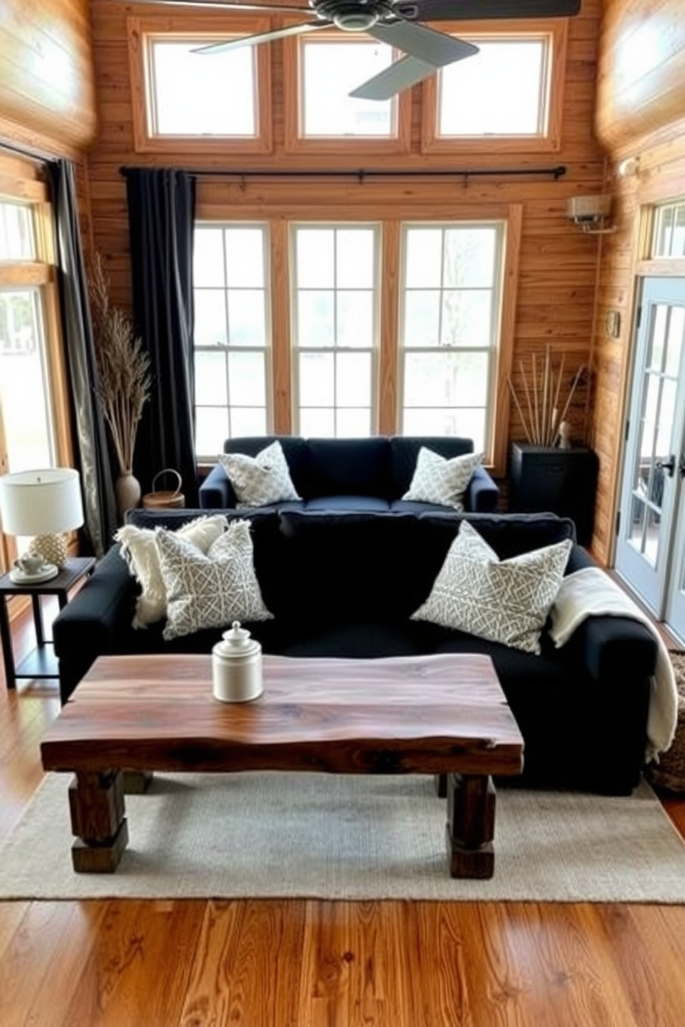 A cozy farmhouse living room featuring natural wood tones throughout the space. A stylish black couch is centered in the room, complemented by a rustic coffee table made of reclaimed wood. The walls are adorned with shiplap, creating a warm and inviting atmosphere. Large windows allow natural light to flood the room, highlighting the earthy color palette and textured throw pillows on the couch.