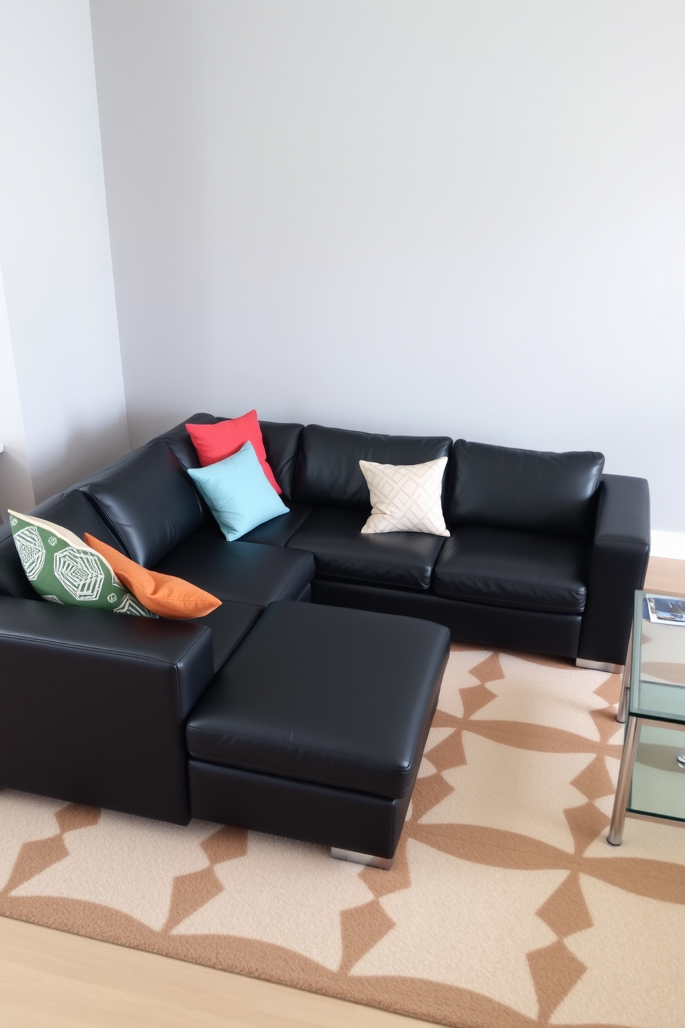 A sleek black leather sectional sofa is the centerpiece of a modern family room. The sofa is adorned with colorful throw pillows and is paired with a stylish glass coffee table. The walls are painted in a soft gray, creating a cozy yet contemporary atmosphere. A large area rug with geometric patterns lies beneath the sofa, adding warmth and texture to the space.