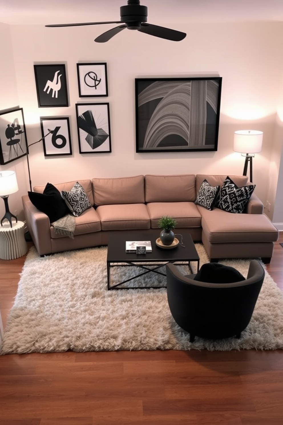 A cozy family room featuring a comfortable sectional sofa in a warm gray fabric. The walls are adorned with black framed artwork that adds visual interest and a modern touch to the space. A large coffee table sits in the center, surrounded by plush area rugs that provide a soft contrast to the hardwood floor. Soft lighting from stylish floor lamps creates an inviting atmosphere for relaxation and gatherings.