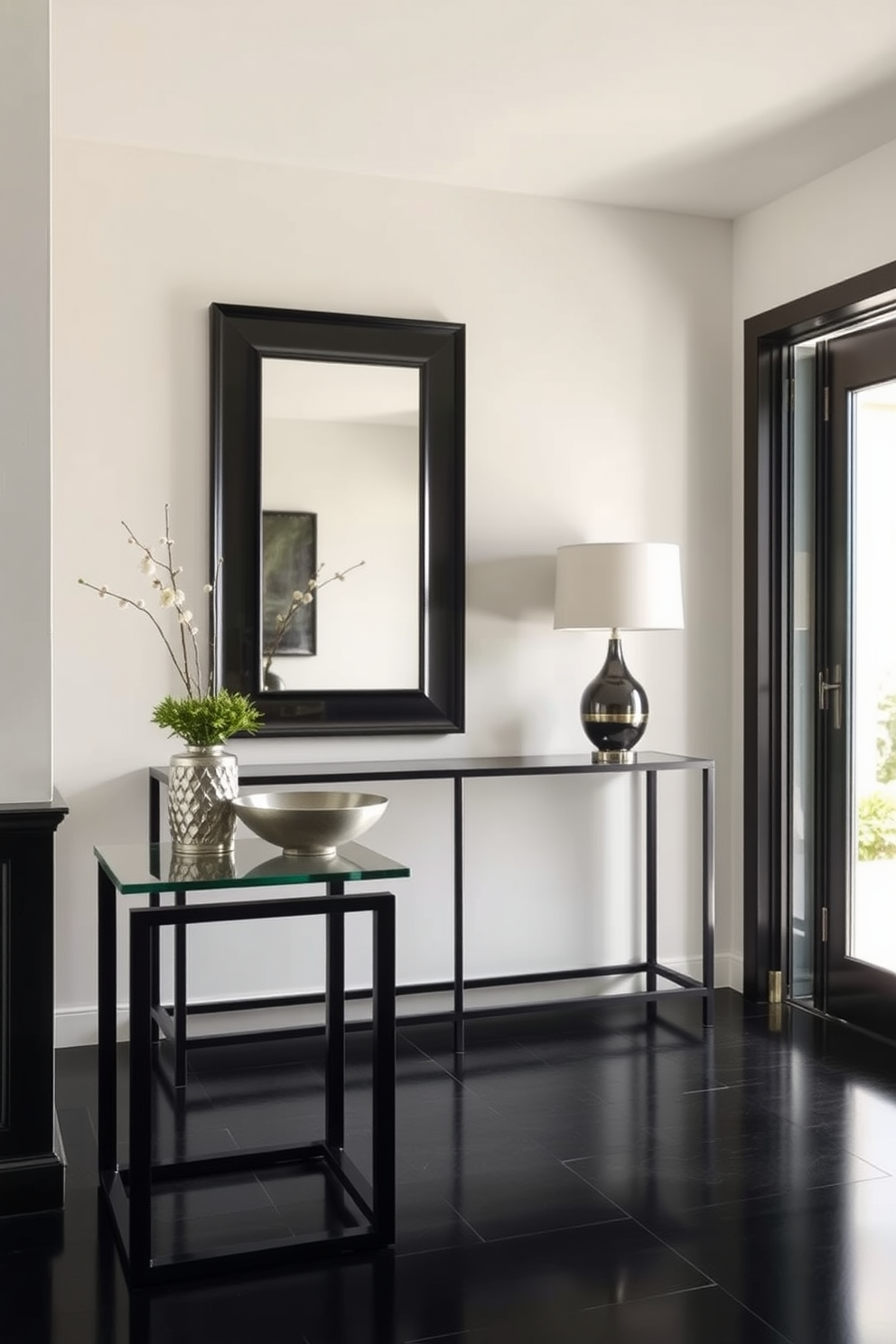 A sophisticated black and glass side table stands elegantly in a well-lit foyer. The table features sleek lines and a minimalist design, complemented by a stylish decorative bowl and a small potted plant on top. The foyer design embraces a modern aesthetic with a striking black color palette. A large mirror with a black frame hangs above a console table, reflecting the natural light that fills the space.