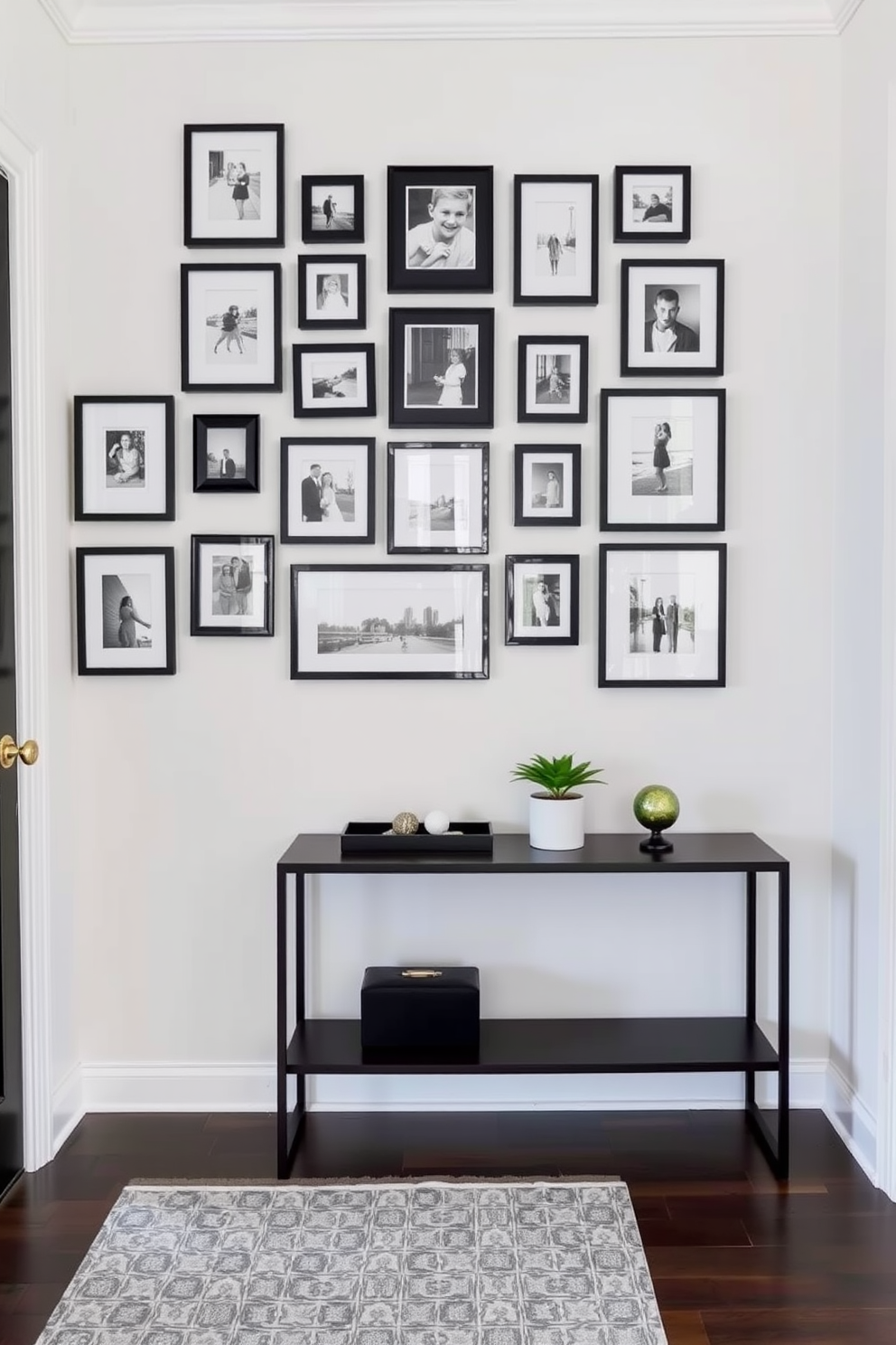 A charming foyer design featuring an array of black and white photo frames arranged in a gallery style on a light-colored wall. The floor is adorned with a stylish runner rug, and a sleek console table sits beneath the framed photos, showcasing decorative items and a small potted plant.