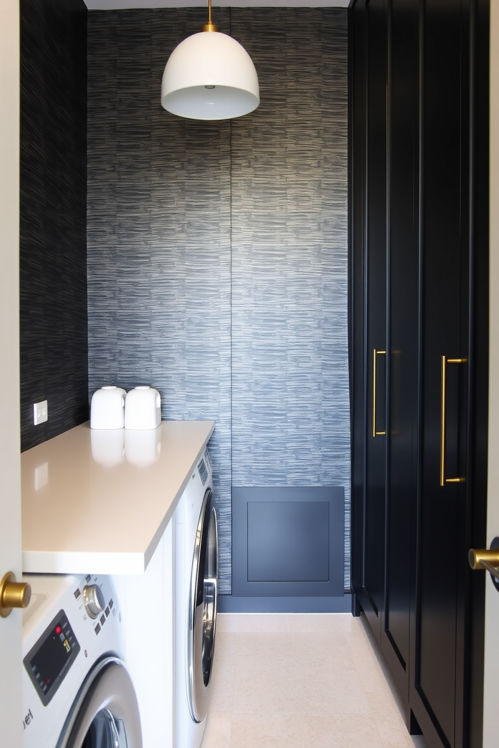 A modern laundry room featuring textured black wallpaper that adds depth and sophistication to the space. The room includes sleek black cabinetry with gold hardware and a large white countertop for folding clothes.