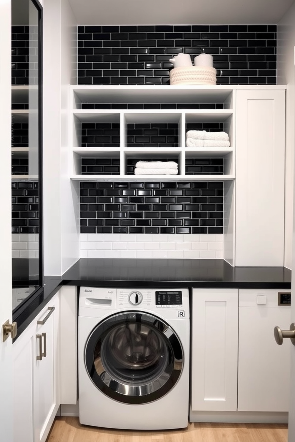 A sleek laundry room featuring a striking black tile backsplash that adds a modern touch. The walls are painted in a crisp white, providing a clean contrast to the dark tiles and enhancing the overall brightness of the space. Incorporate a spacious black countertop for folding clothes, complemented by stylish open shelving above for storage. A contemporary washing machine and dryer are seamlessly integrated into the cabinetry, creating a cohesive and functional design.