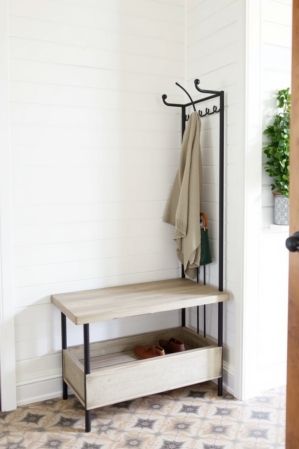 A vintage-inspired black metal coat rack stands prominently in the corner of a stylish mudroom. The walls are adorned with shiplap in a soft white hue, creating a bright and welcoming atmosphere. Beneath the coat rack, a rustic bench with a weathered finish provides a comfortable spot to sit while putting on shoes. The floor is covered with a durable patterned tile that adds a touch of personality to the space.