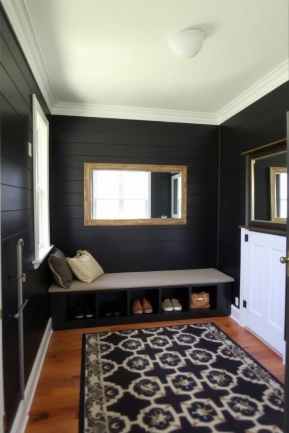 A stylish mudroom with black shiplap walls and crisp white trim. The space features a built-in bench with plush seating and storage cubbies above for shoes and bags. On the floor, a durable patterned rug adds warmth and texture. A large mirror hangs on the wall, reflecting natural light from a nearby window.