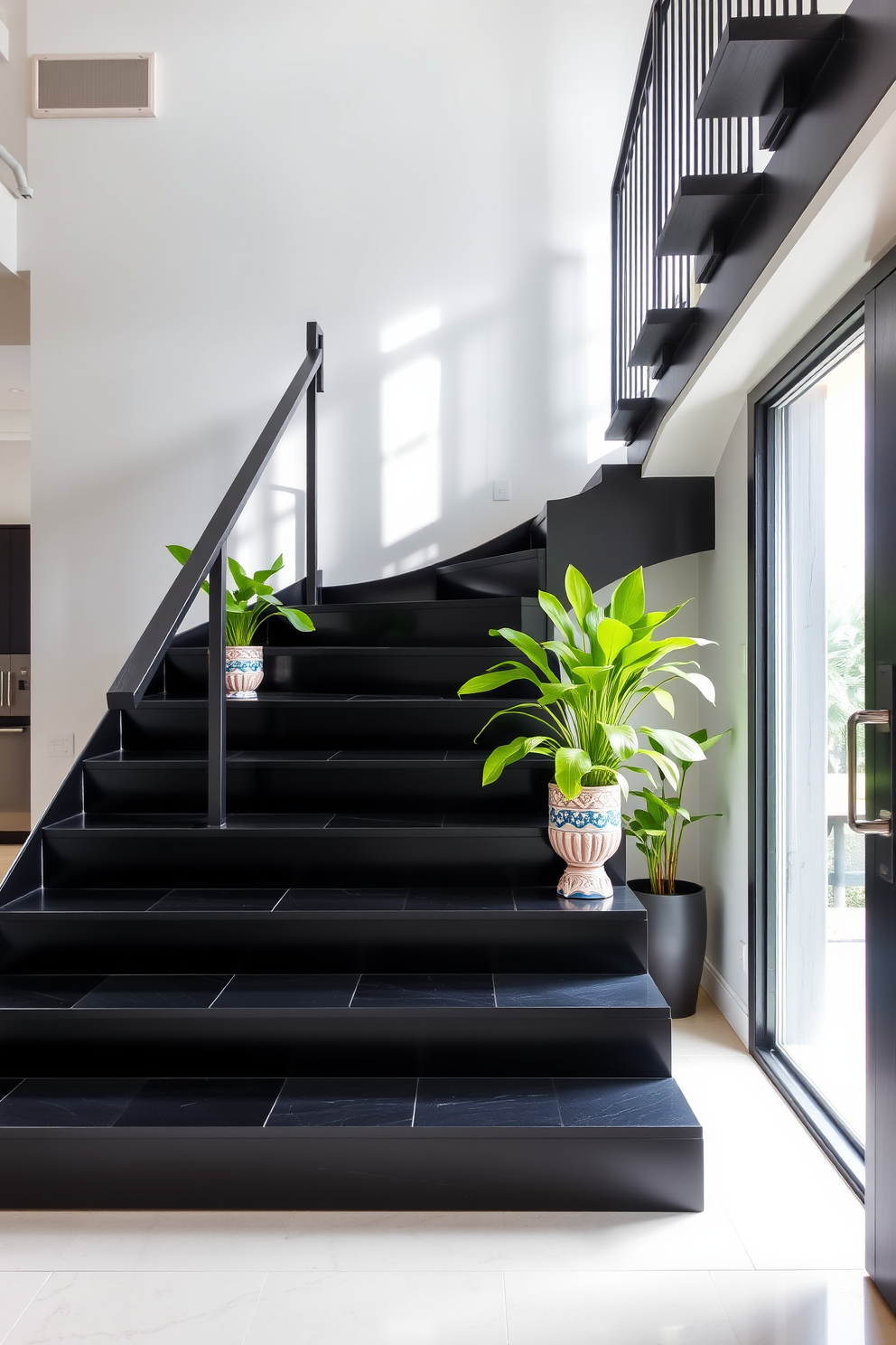 A striking black staircase with sleek, modern lines serves as the focal point of the entryway. Lush green plants in decorative pots are strategically placed along the staircase, adding vibrant splashes of color and life to the space. The staircase features a minimalist railing that complements its bold design. Natural light floods in from a nearby window, highlighting the contrast between the black steps and the greenery.