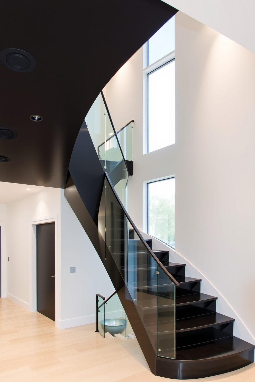 An elegant curved black staircase gracefully ascends, featuring sleek glass railings that enhance its modern aesthetic. The staircase is illuminated by soft recessed lighting, creating a striking focal point in the entryway.