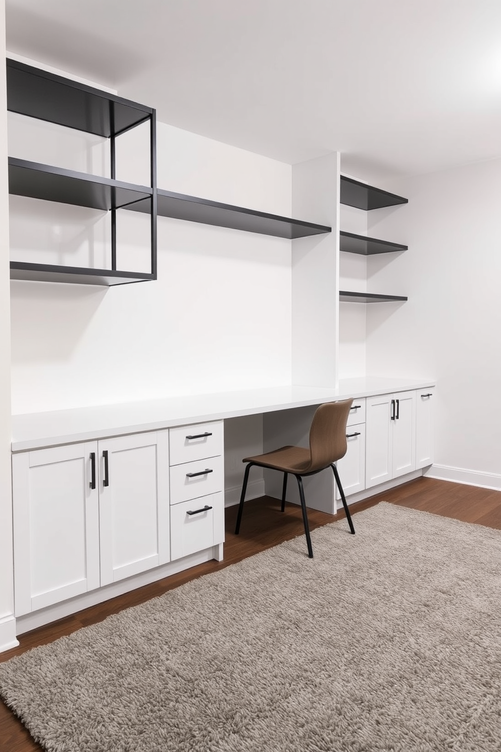 A sleek white built-in desk is positioned against the wall, complemented by stylish black shelving above it. The basement features a modern aesthetic with a monochromatic color scheme, highlighting the contrast between the white desk and the black shelving. The walls are painted in a soft white hue, creating an open and airy feel in the space. A plush area rug in shades of gray adds warmth and texture to the otherwise minimalist design.