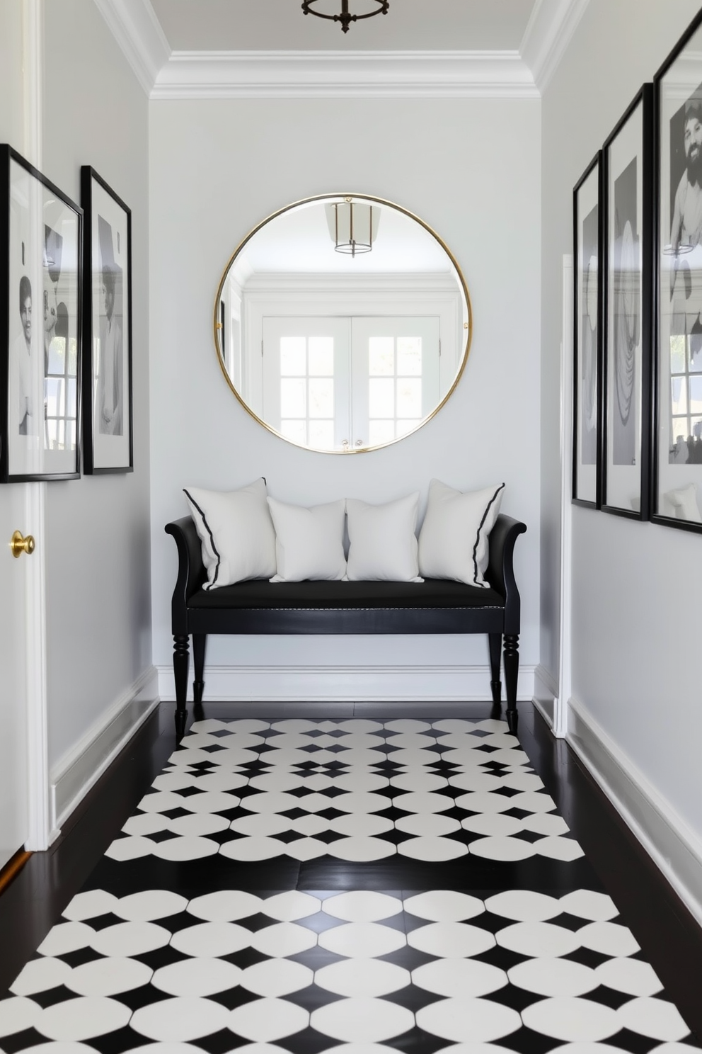 A classic black bench with plush white cushions sits elegantly in the foyer. The walls are adorned with black and white artwork, creating a striking contrast that enhances the sophisticated atmosphere. The floor features a chic black and white patterned tile that leads visitors into the space. A large round mirror above the bench reflects natural light, making the foyer feel open and inviting.