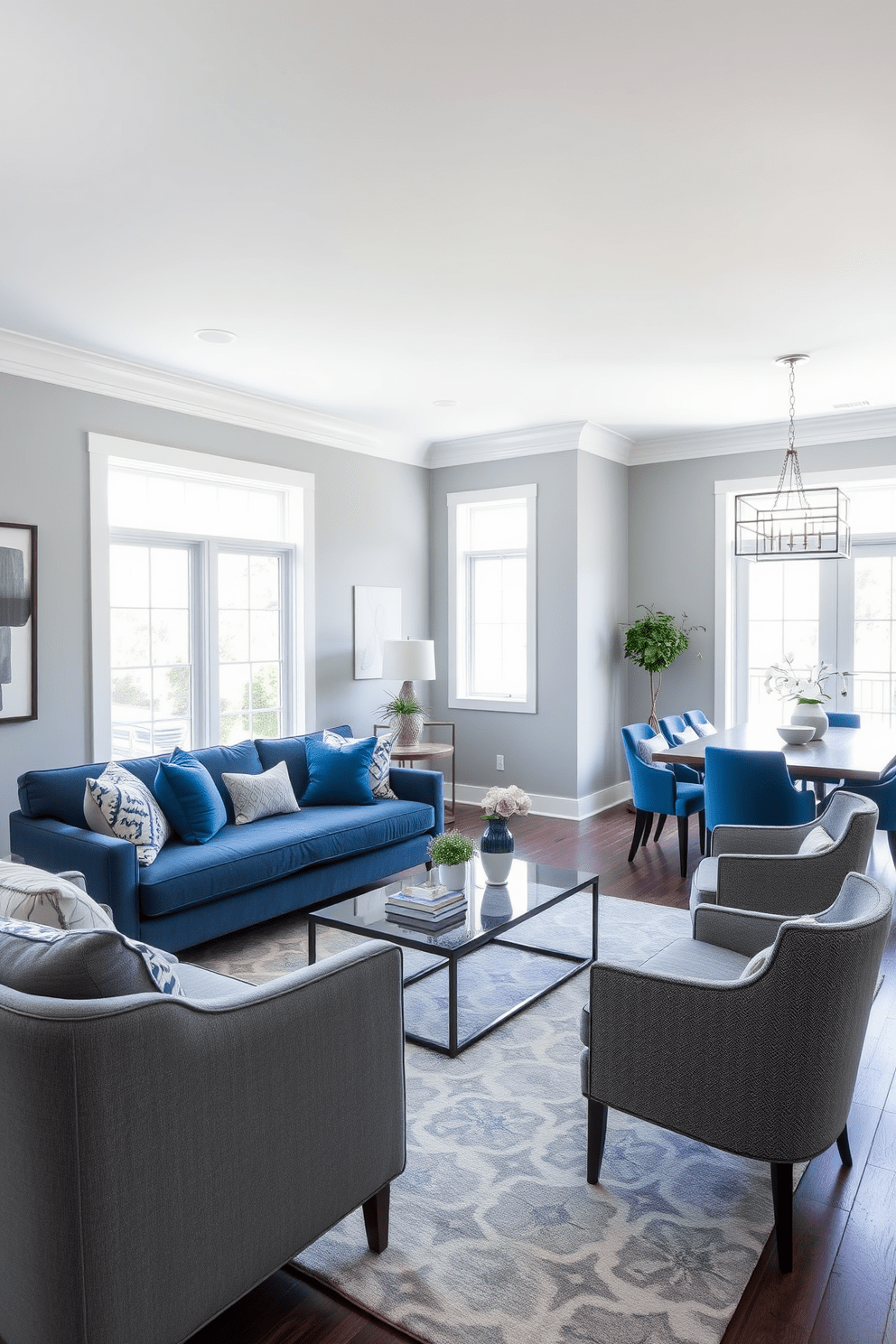 A stylish living room featuring a blue and gray color scheme. The walls are painted a soft gray while the furniture includes a plush blue sofa and gray accent chairs. A modern coffee table sits in the center, surrounded by a patterned area rug that incorporates both colors. Large windows allow natural light to fill the space, highlighting decorative blue and gray throw pillows on the sofa. The dining area showcases a sleek gray dining table with blue upholstered chairs. A statement light fixture hangs above, adding a touch of elegance to the overall design.