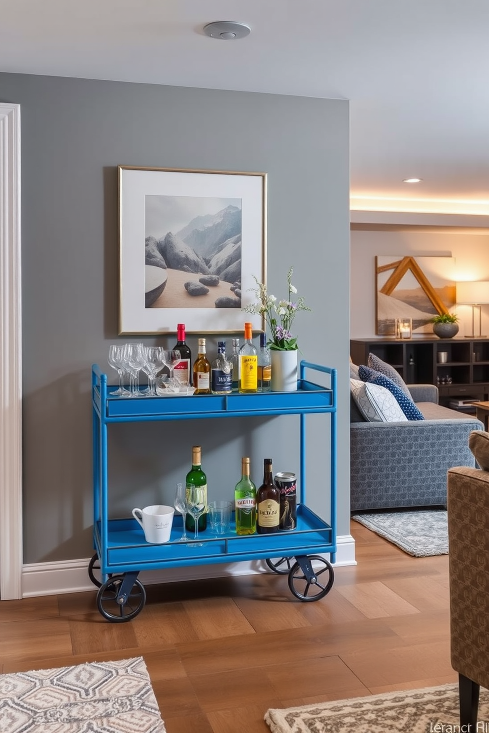 A stylish blue bar cart is elegantly positioned against a wall adorned with art. The cart is stocked with an array of glassware and colorful bottles, complemented by a small vase of fresh flowers. The basement features a modern design with cozy seating arrangements and ambient lighting. Soft gray walls and plush rugs create a welcoming atmosphere, perfect for entertaining or relaxing.