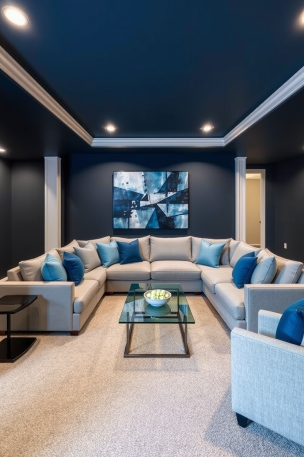 A sophisticated basement design featuring a blue and gray color scheme. The walls are painted in a deep navy blue, complemented by soft gray carpeting that adds warmth to the space. In the center, a plush sectional sofa in light gray is arranged around a sleek coffee table with a glass top. Accent pillows in varying shades of blue provide a pop of color, while a large abstract painting in blues and grays hangs on the wall.