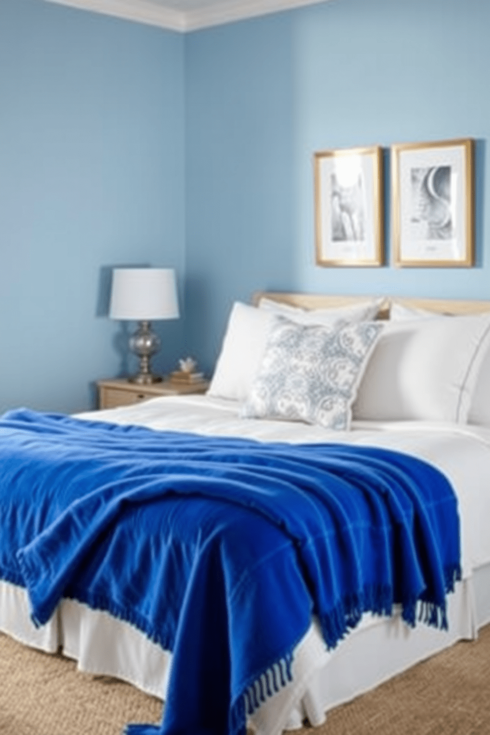 A cozy blue bedroom featuring royal blue throw blankets draped over a plush bed. The walls are painted a soft light blue, creating a serene atmosphere complemented by white bedding and decorative pillows.