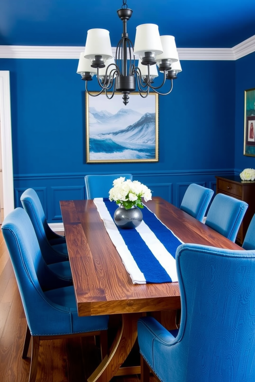 A chic blue dining room features a large wooden table adorned with an indigo and white striped table runner. Surrounding the table are elegant upholstered chairs in a complementary shade of blue, creating a harmonious and inviting atmosphere.