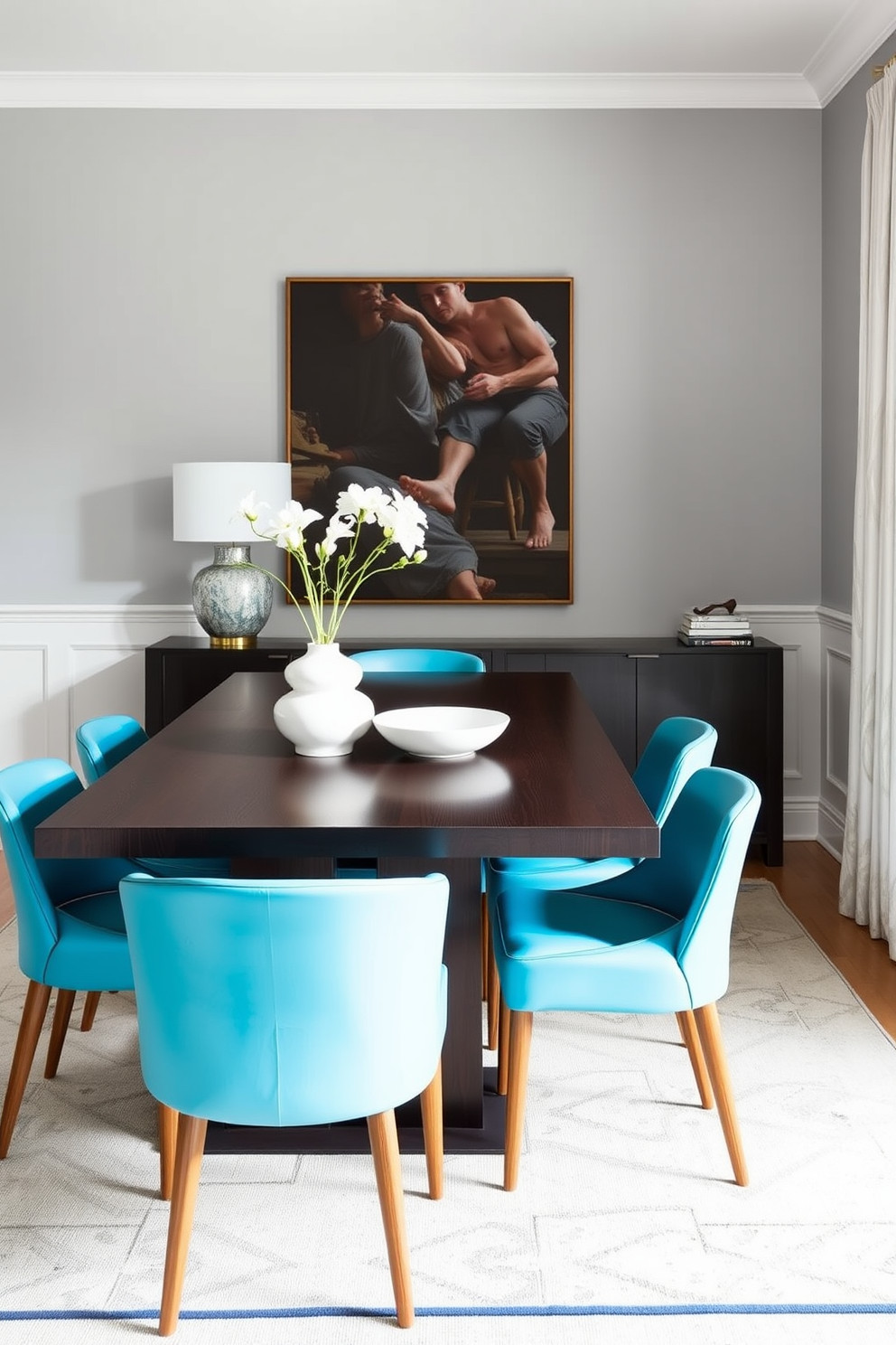 A stylish dining room featuring turquoise chairs arranged around a sleek dark wooden table. The walls are painted in a soft gray hue, creating a modern and inviting atmosphere.