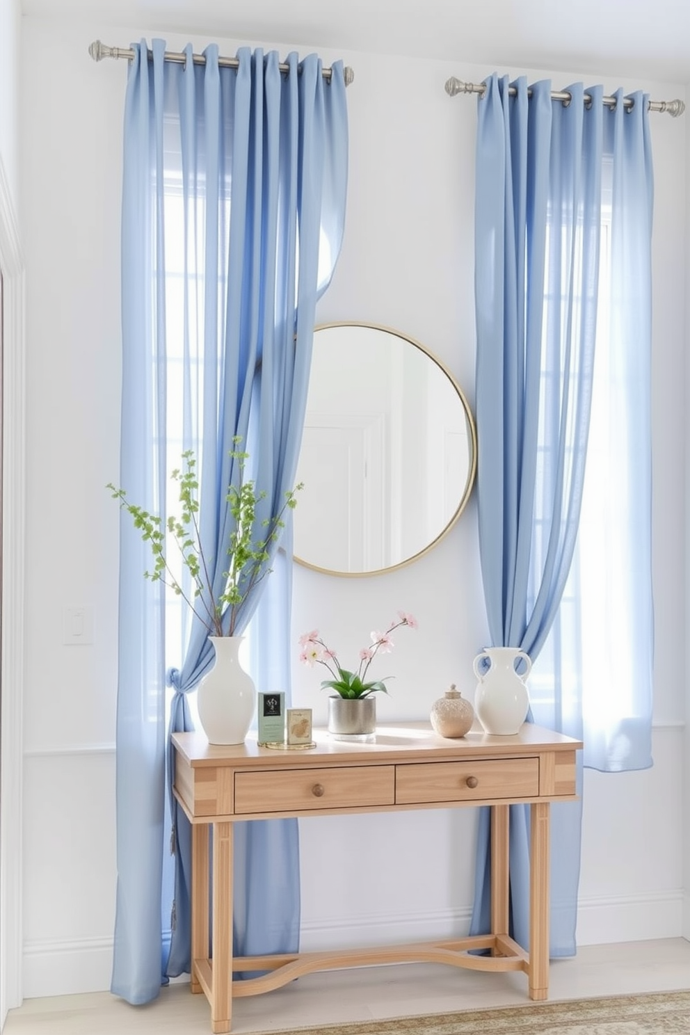 Soft blue curtains with sheer fabric gracefully frame the windows, allowing natural light to filter in while adding a touch of elegance to the space. The walls are painted in a soft white, creating a bright and airy atmosphere that complements the serene color of the curtains. The foyer features a stylish console table made of light wood, adorned with decorative items and a small potted plant. A large round mirror hangs above the table, reflecting the soft hues of the curtains and enhancing the welcoming ambiance of the entryway.