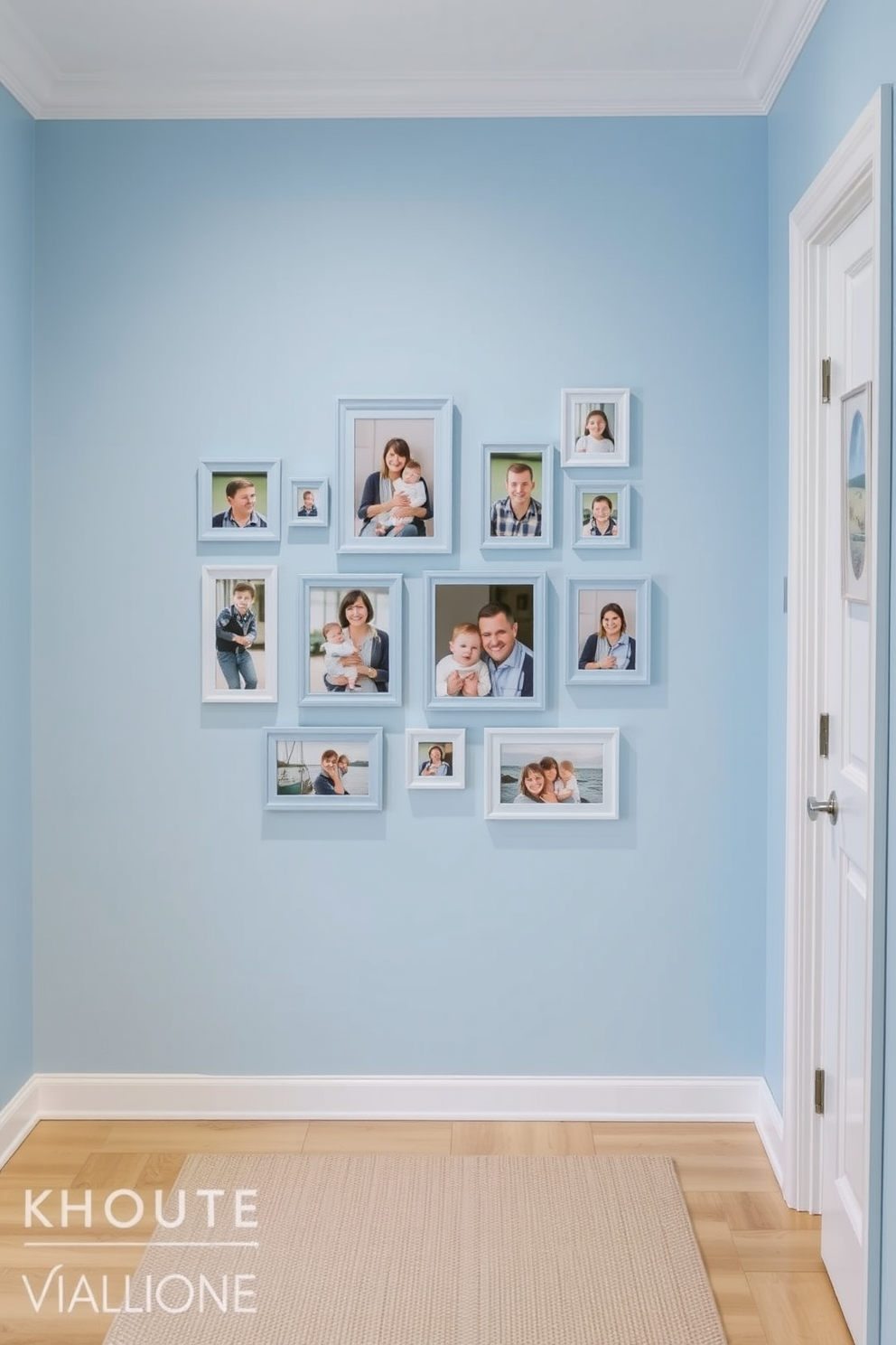 A light blue foyer features a gallery wall adorned with family photos in matching light blue frames. The floor is covered with a soft beige rug that complements the serene color palette, creating a welcoming atmosphere.